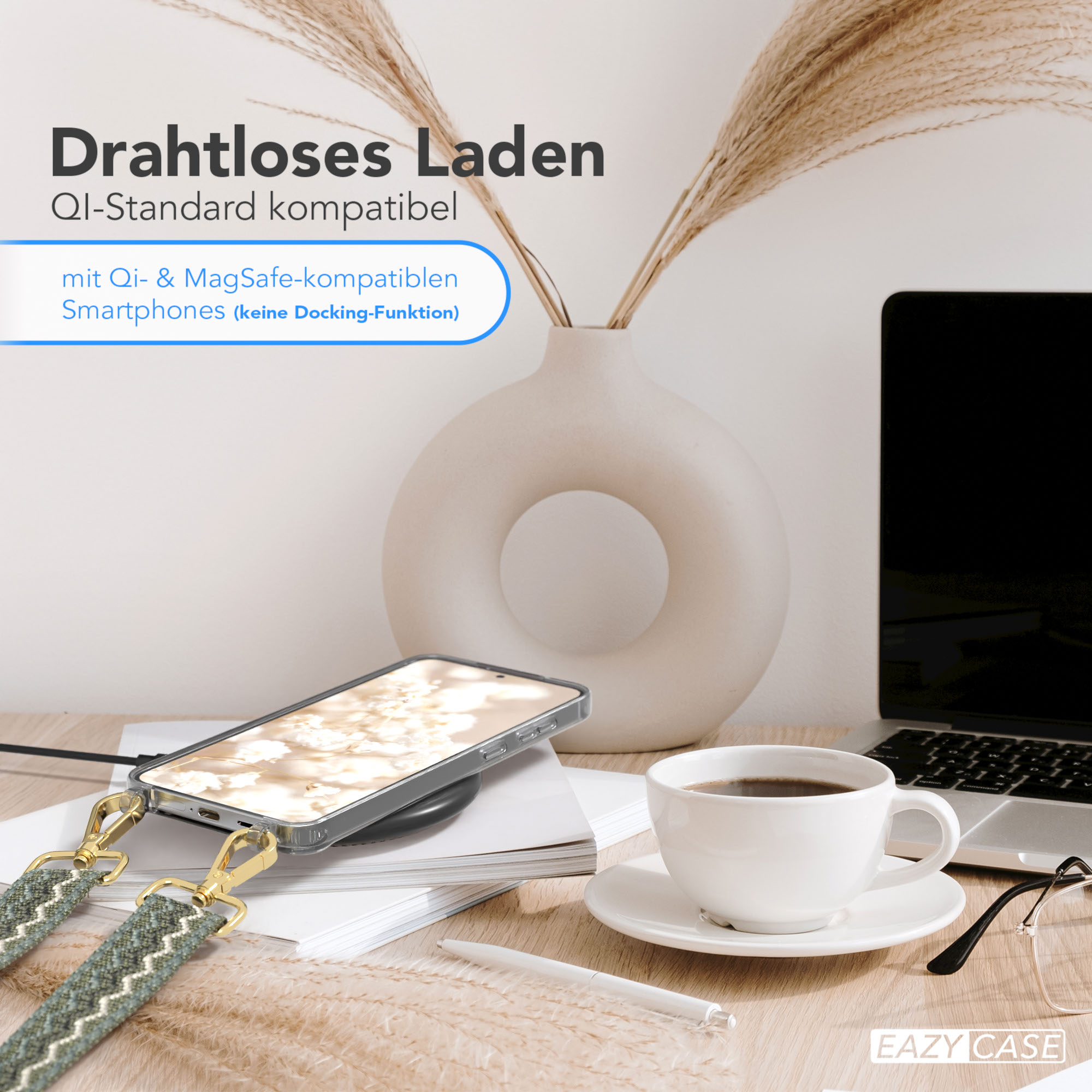 Ein Telefon liegt auf einem kabellosen Ladegerät. Eine Tasse Kaffee und ein Laptop stehen auf dem Tisch.