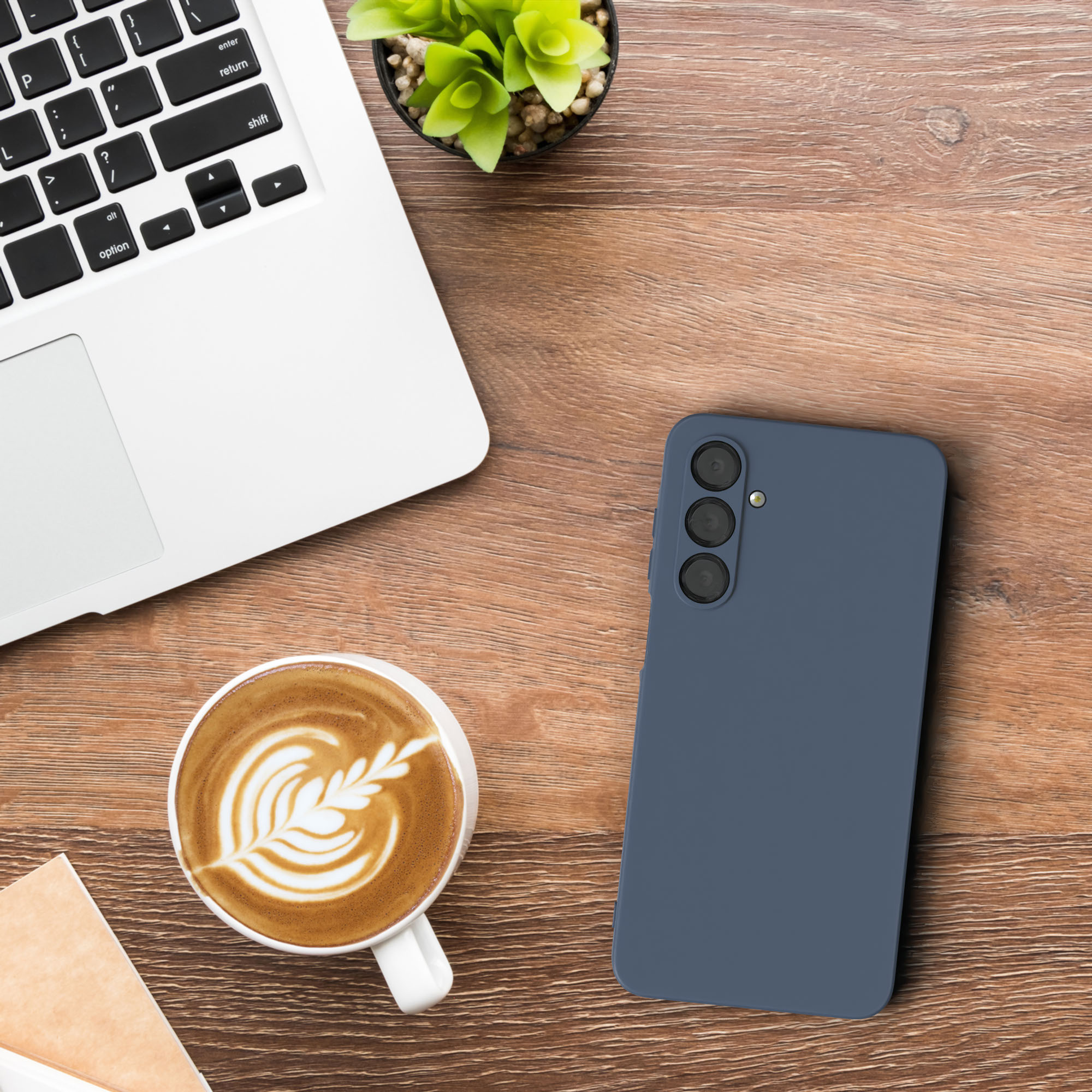 Ein Telefon und eine Kaffeetasse mit Laptop auf einem Holzschreibtisch. Draufsicht.