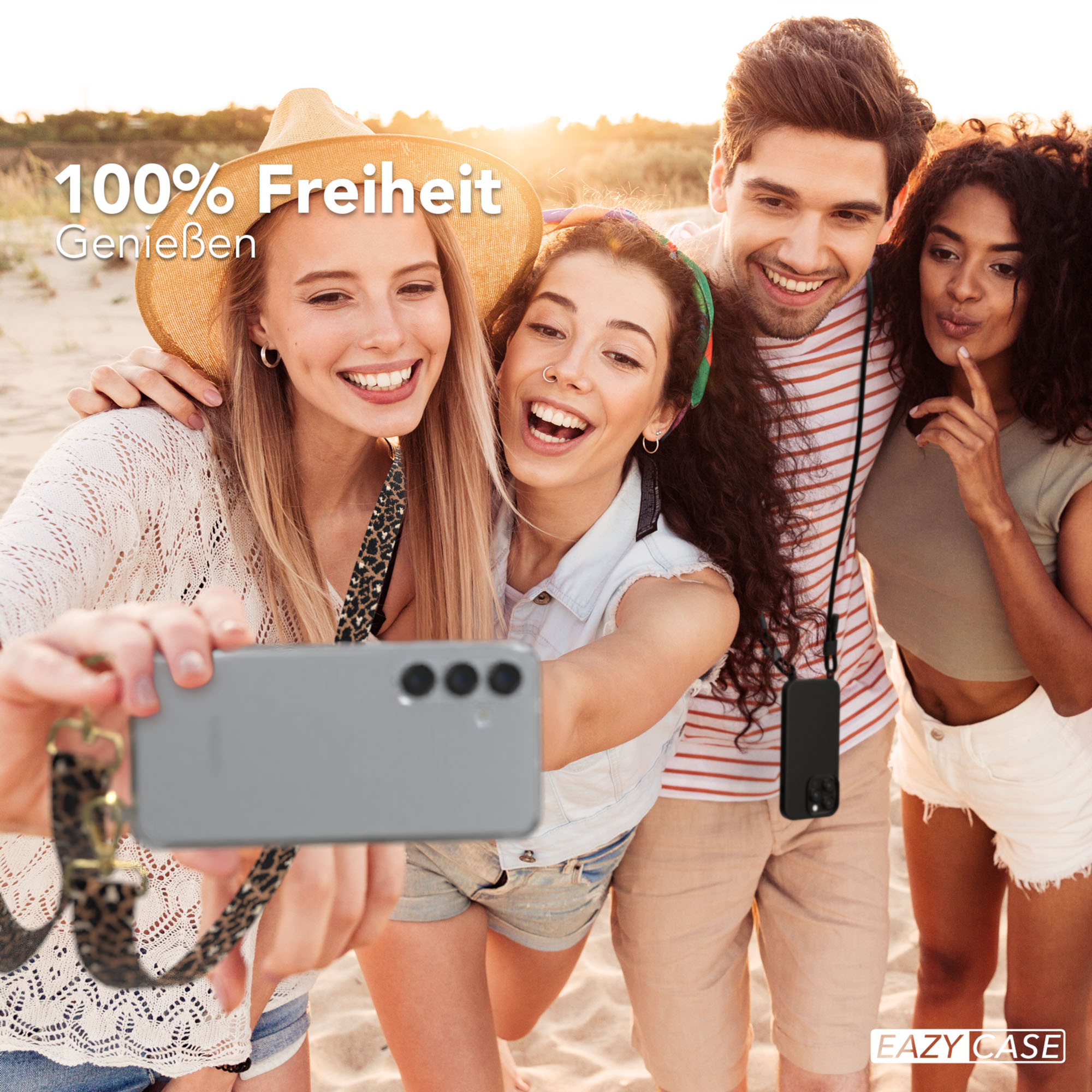 Vier Personen machen ein Selfie mit einem Handy. Strandkulisse, fröhliche Gesichter.