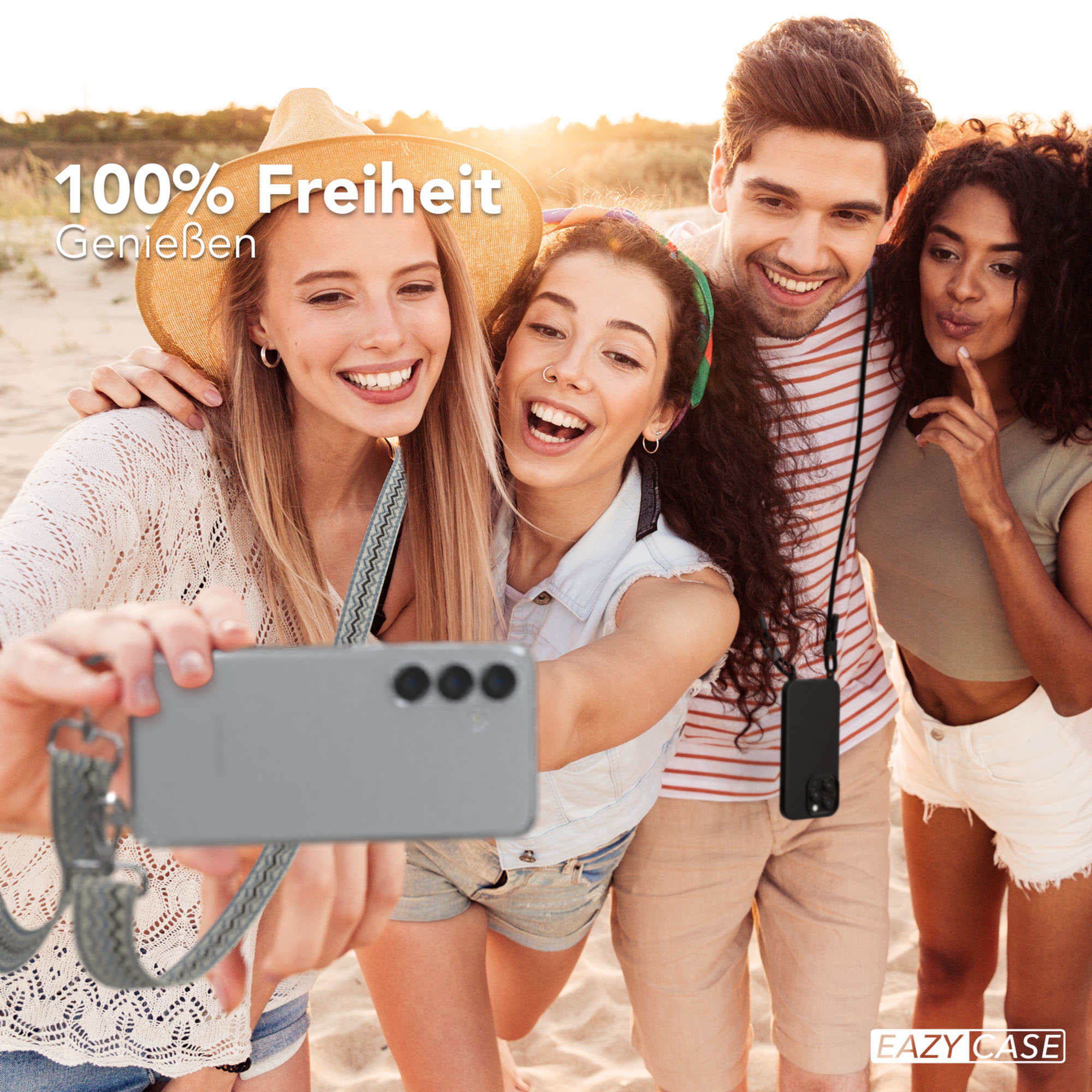 Vier Personen machen ein Selfie am Strand, halten ein Telefon.