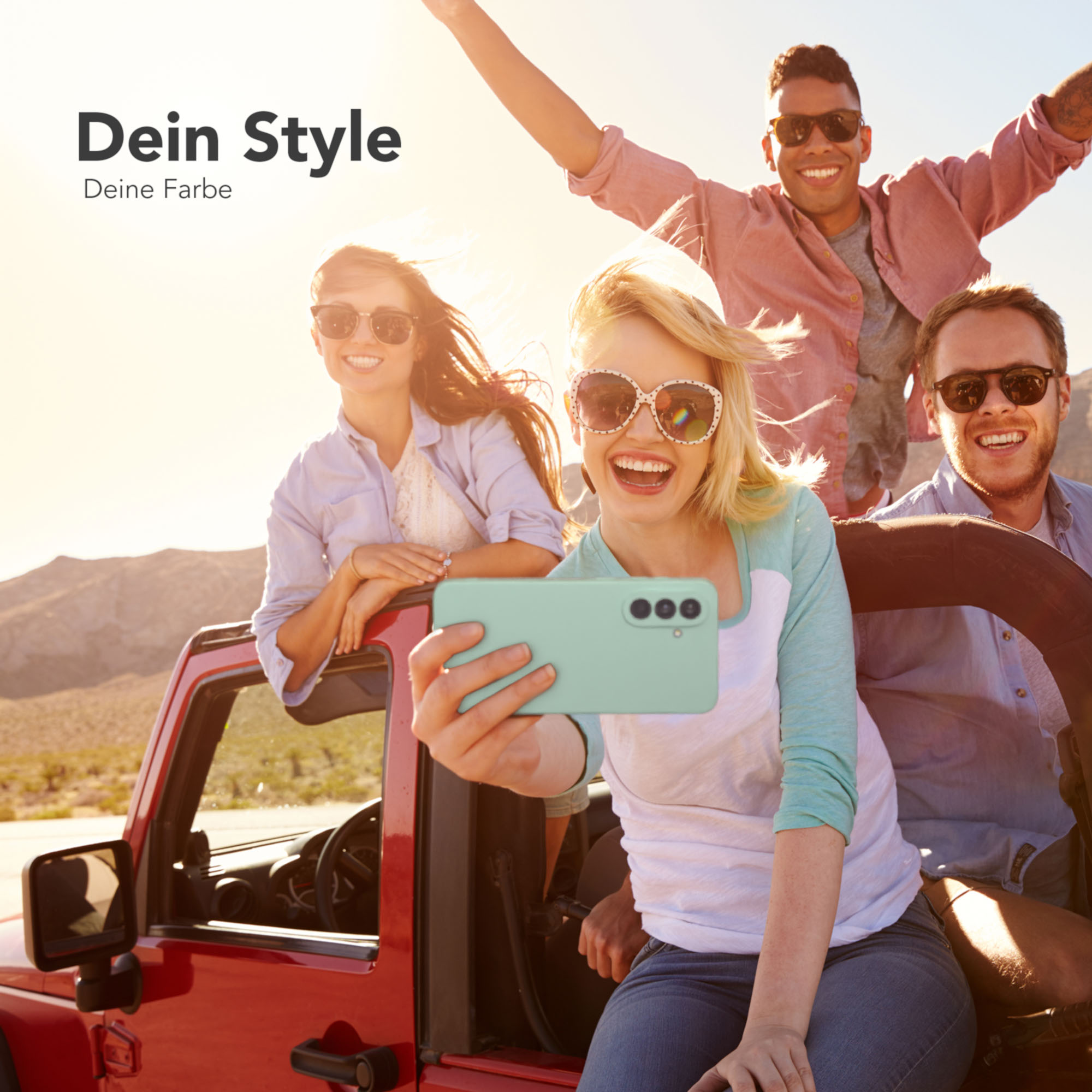 Vier lächelnde Personen machen ein Selfie mit einer mintgrünen Handyhülle in einem roten Jeep.