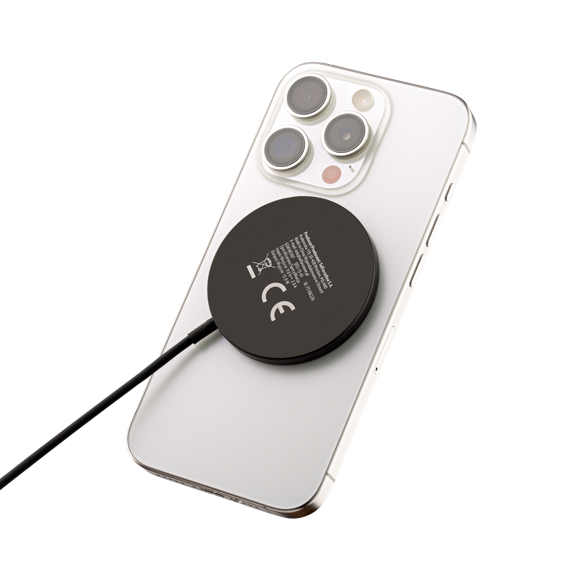 Biały telefon z dołączoną ładowarką MagSafe. Ładowarka jest czarna.