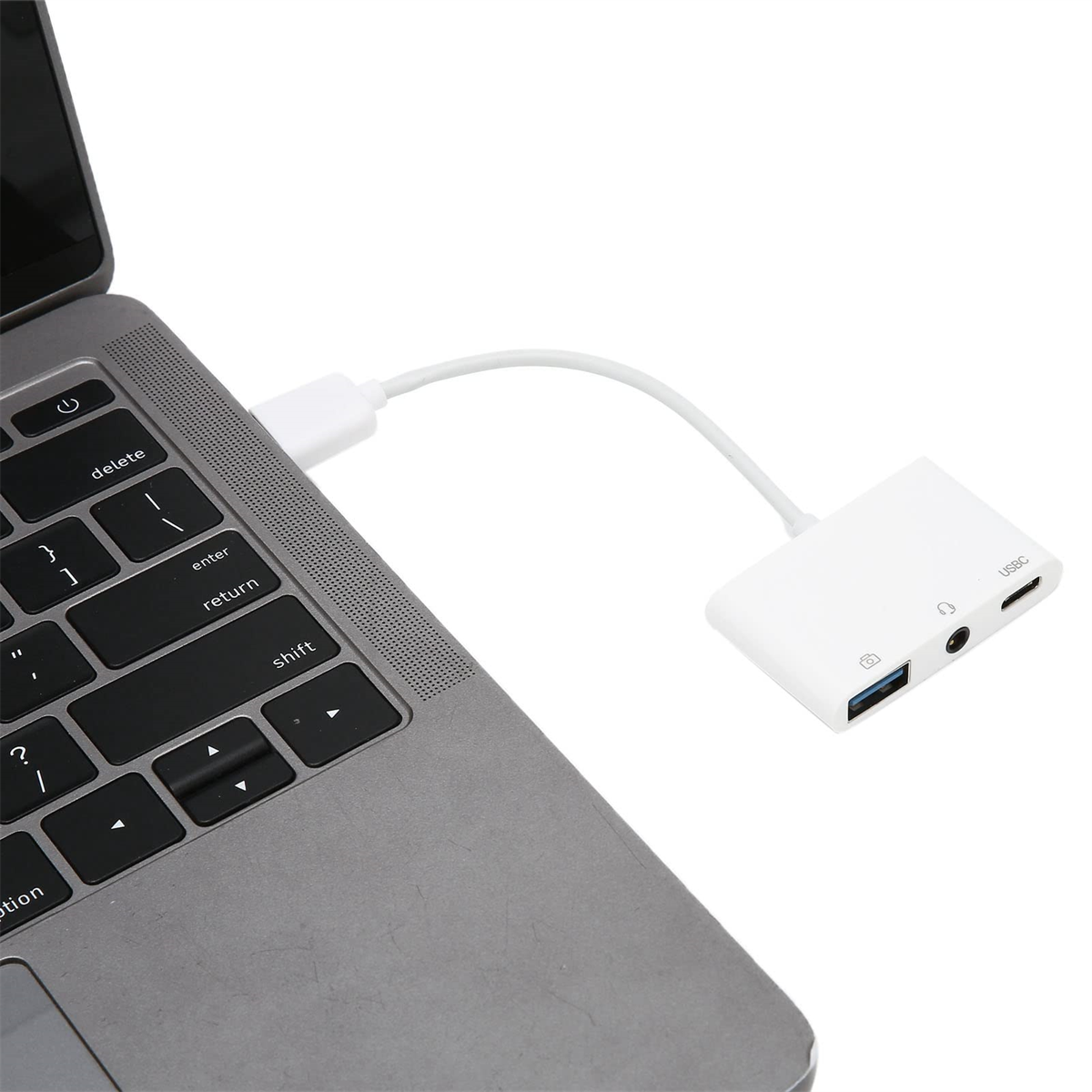 Ein Laptop, der über ein weißes Kabel mit einem USB-Hub verbunden ist. USB-Hub hat Anschlüsse.