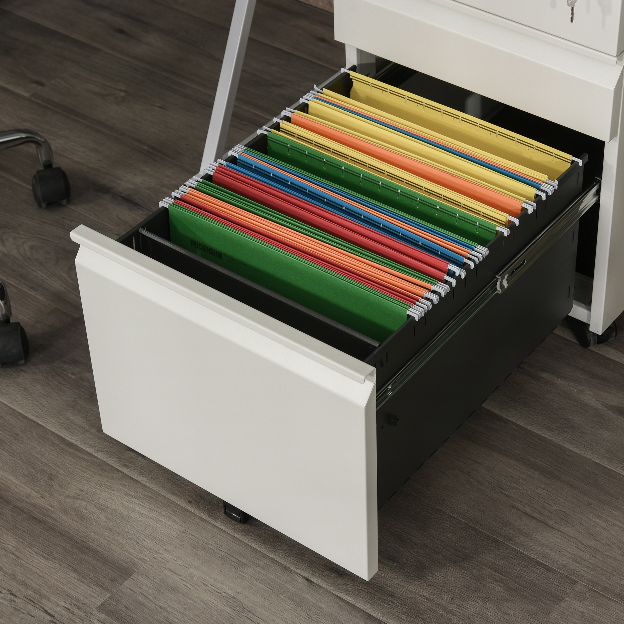 Offene Schublade mit farbigen Aktenordnern. Schublade in weißem Schrank auf Holzboden.