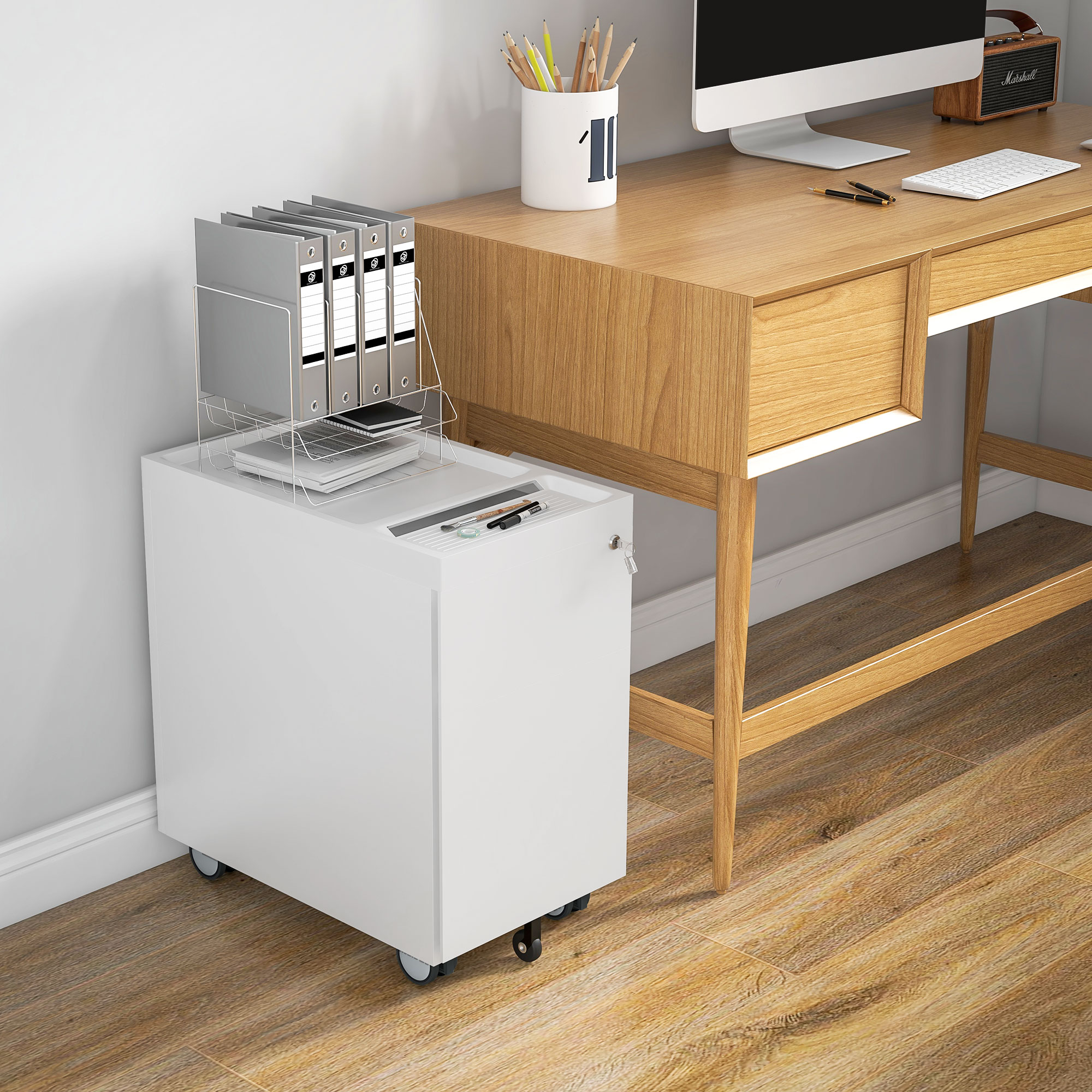 Ein weißer Rollcontainer mit Akten und ein Schreibtisch mit Computer und Stiften.