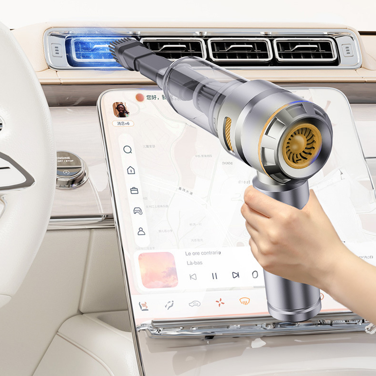 Eine Hand hält einen silber-goldenen Staubsauger in einem Auto, in der Nähe eines Tablets mit Karte.