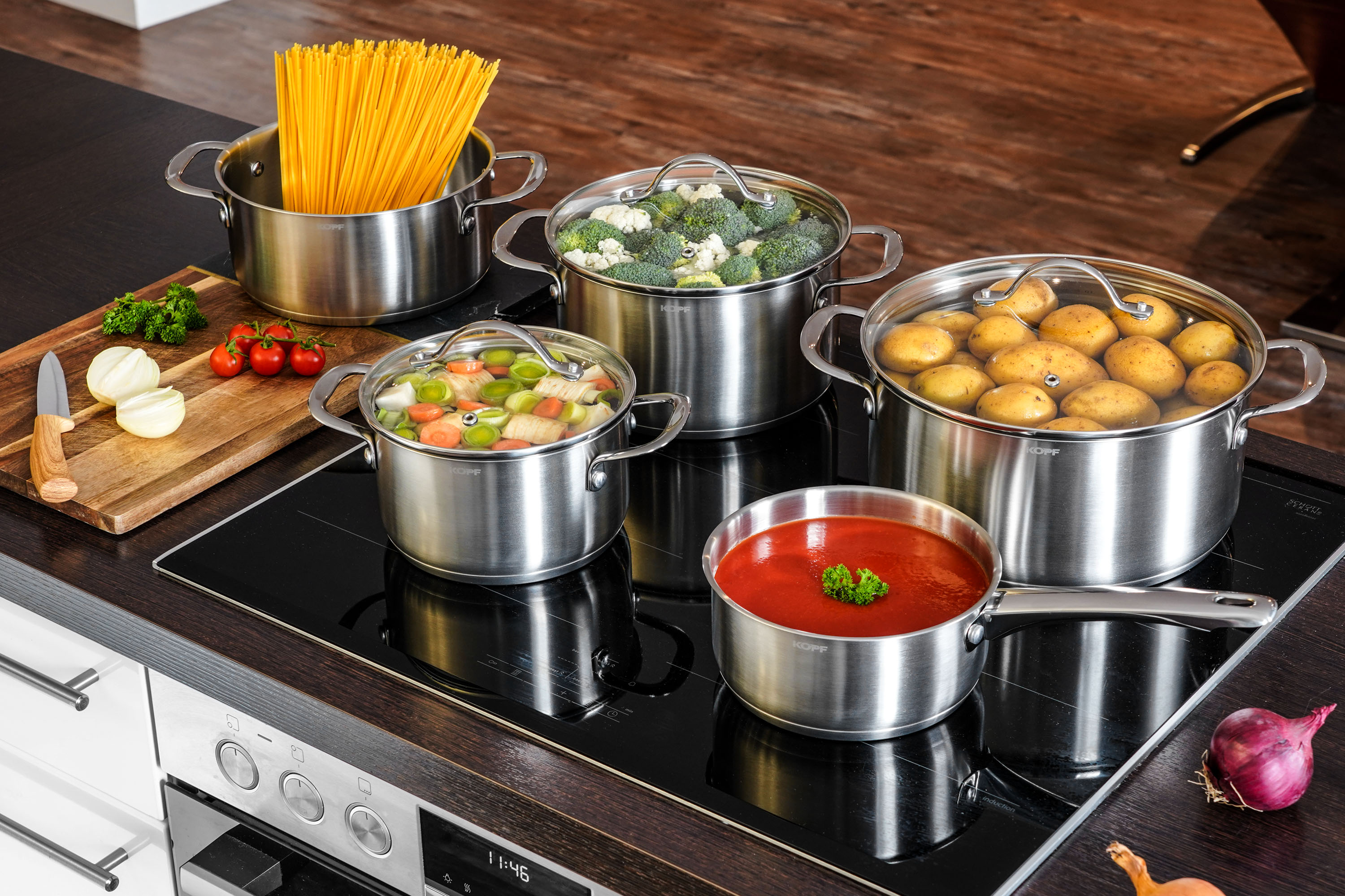 Töpfe mit Essen. Gemüse, Nudeln und Kartoffeln befinden sich in den Töpfen.