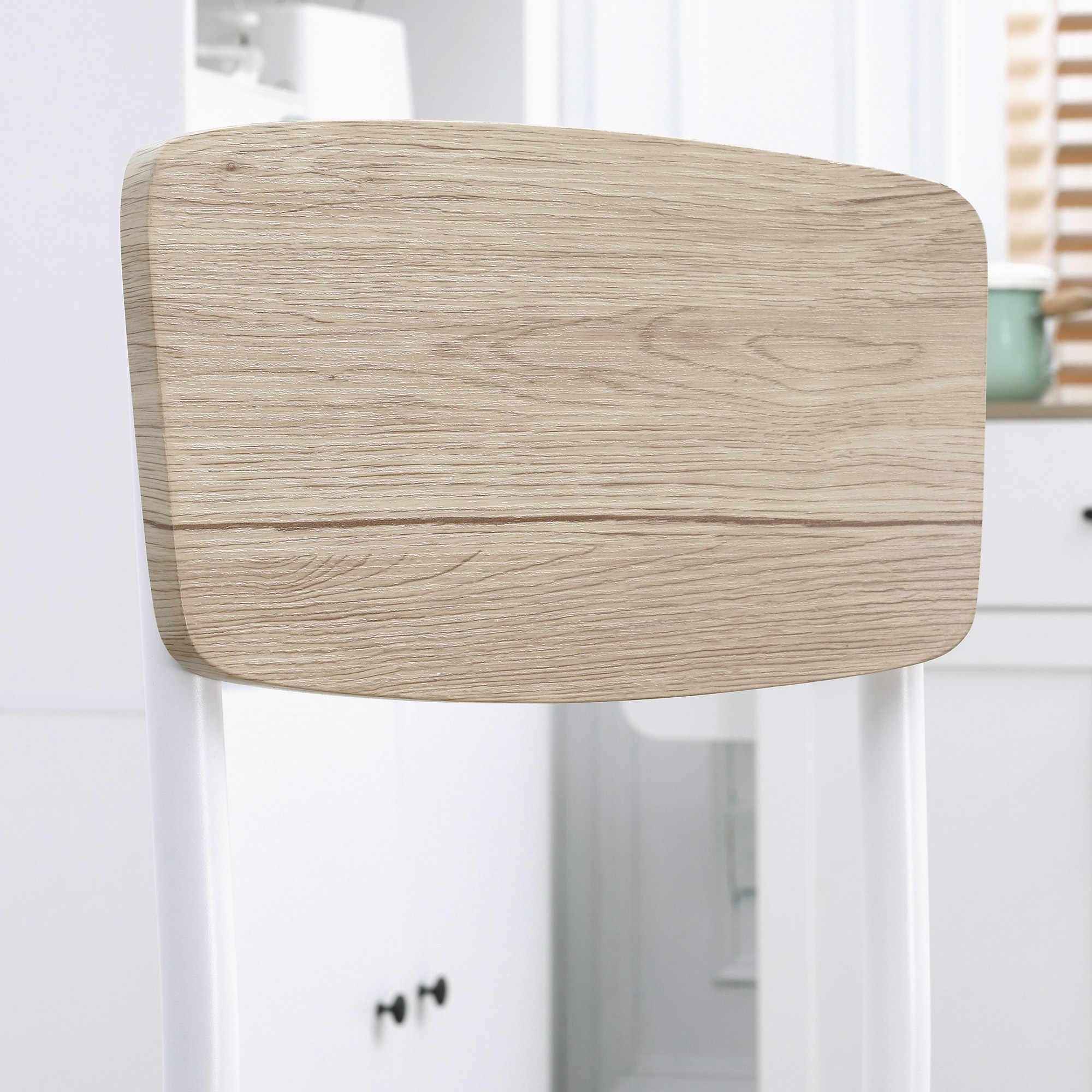 Nahaufnahme einer Stuhllehne mit Holzmaserung. Heller, weißer Hintergrund.