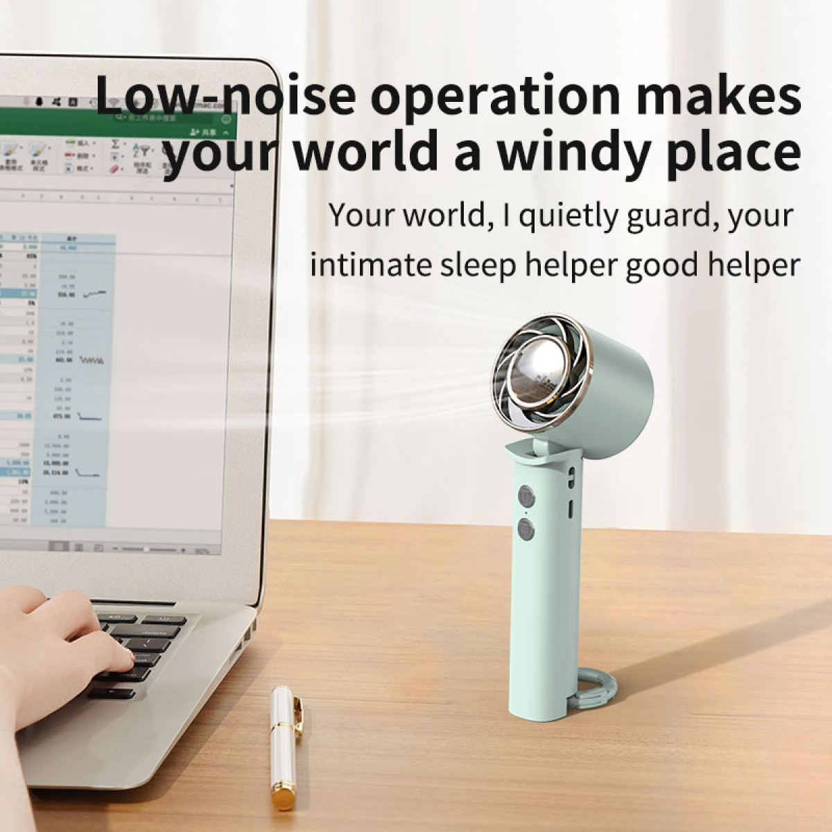 Kleine ventilator op een bureau naast een laptop. Tekst erboven.