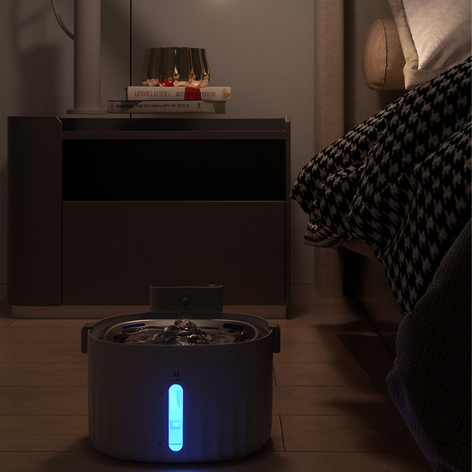 Ein Luftbefeuchter in einem Schlafzimmer, in der Nähe eines Bettes und Nachttisches.