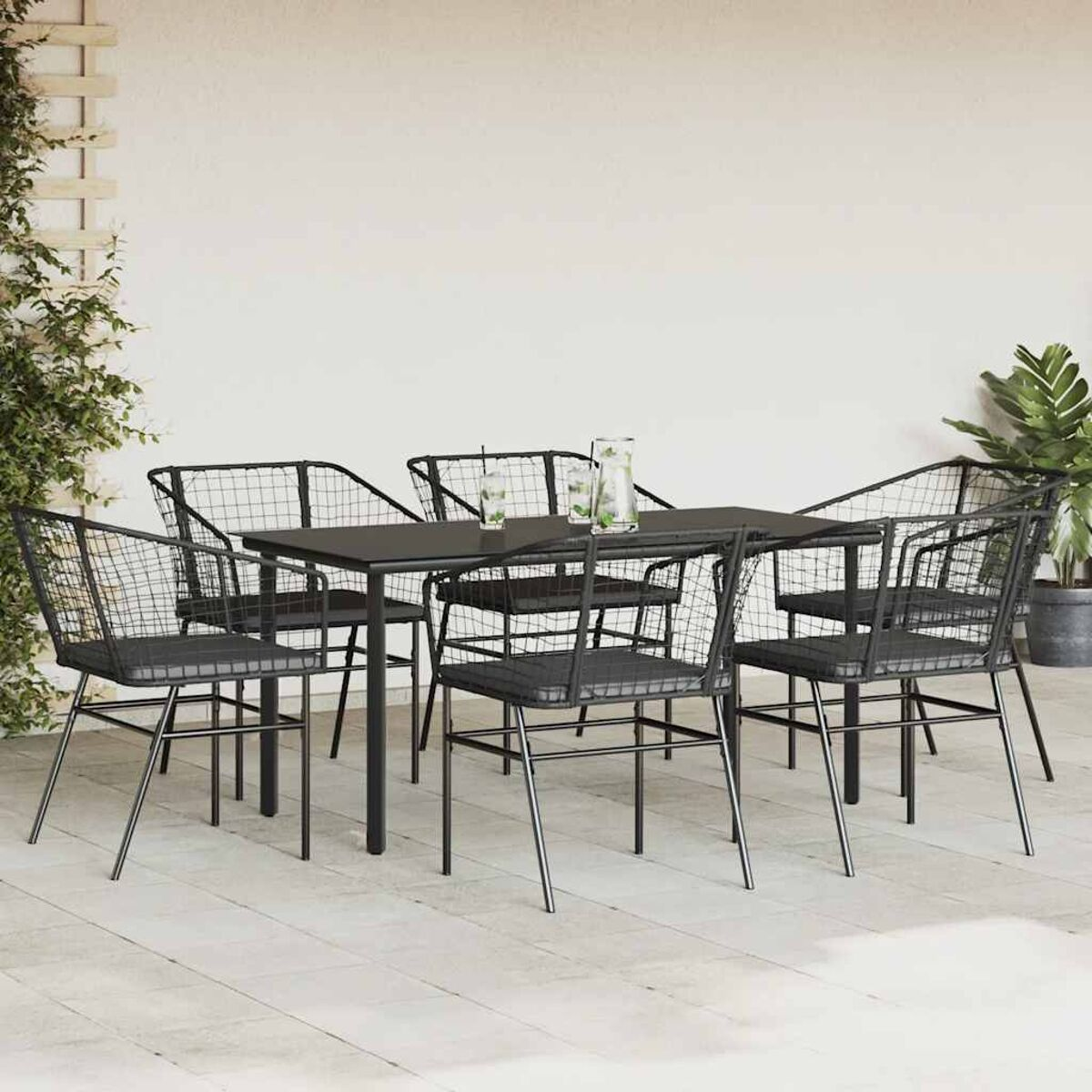 Set da pranzo all'aperto con sedie in filo nero, tavolo nero e sfondo bianco.