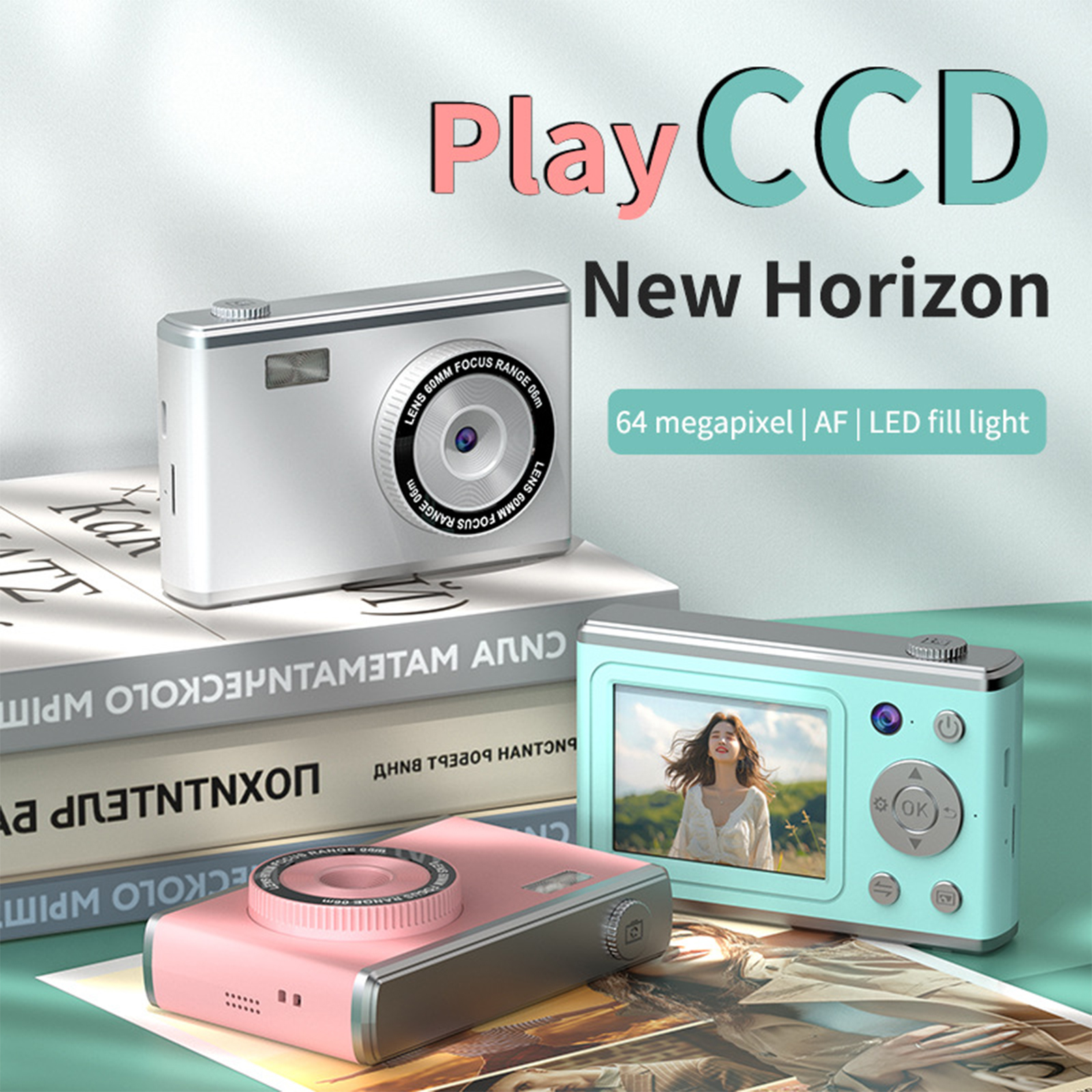Eine pinke und eine türkisblaue Kamera auf einem Bücherstapel. Text: Play CCD, New Horizon, 64 Megapixel...