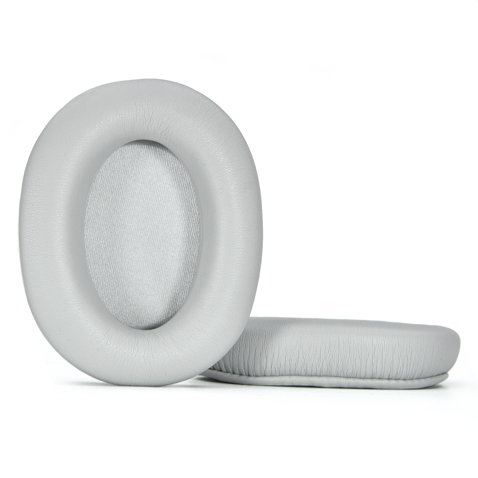 Due cuscinetti per cuffie over-ear grigio chiaro, circolari. Hanno forma ovale e sono su sfondo bianco.