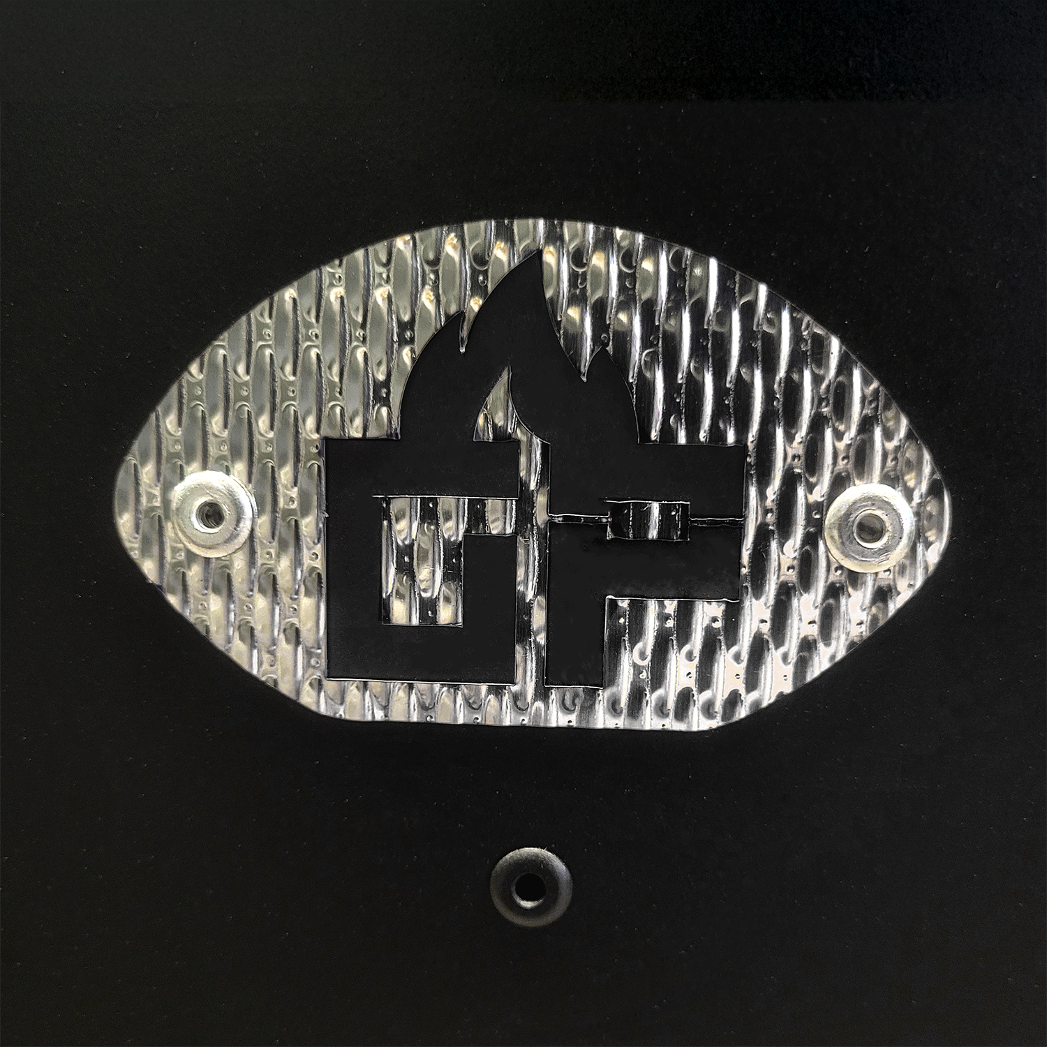 Schwarz-silbernes Emblem mit Flamme und Buchstaben 'GF' auf schwarzem Grund.