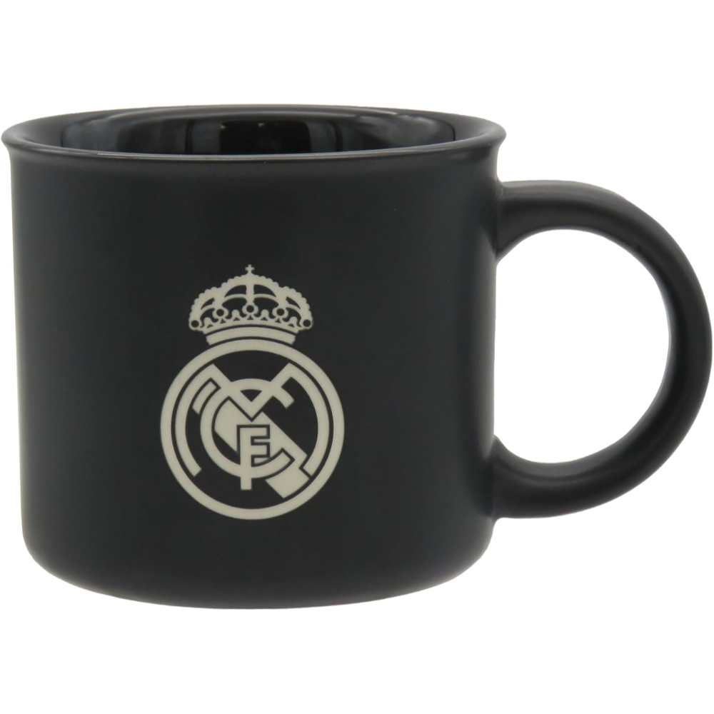 Taza negra con el escudo del Real Madrid en blanco.
