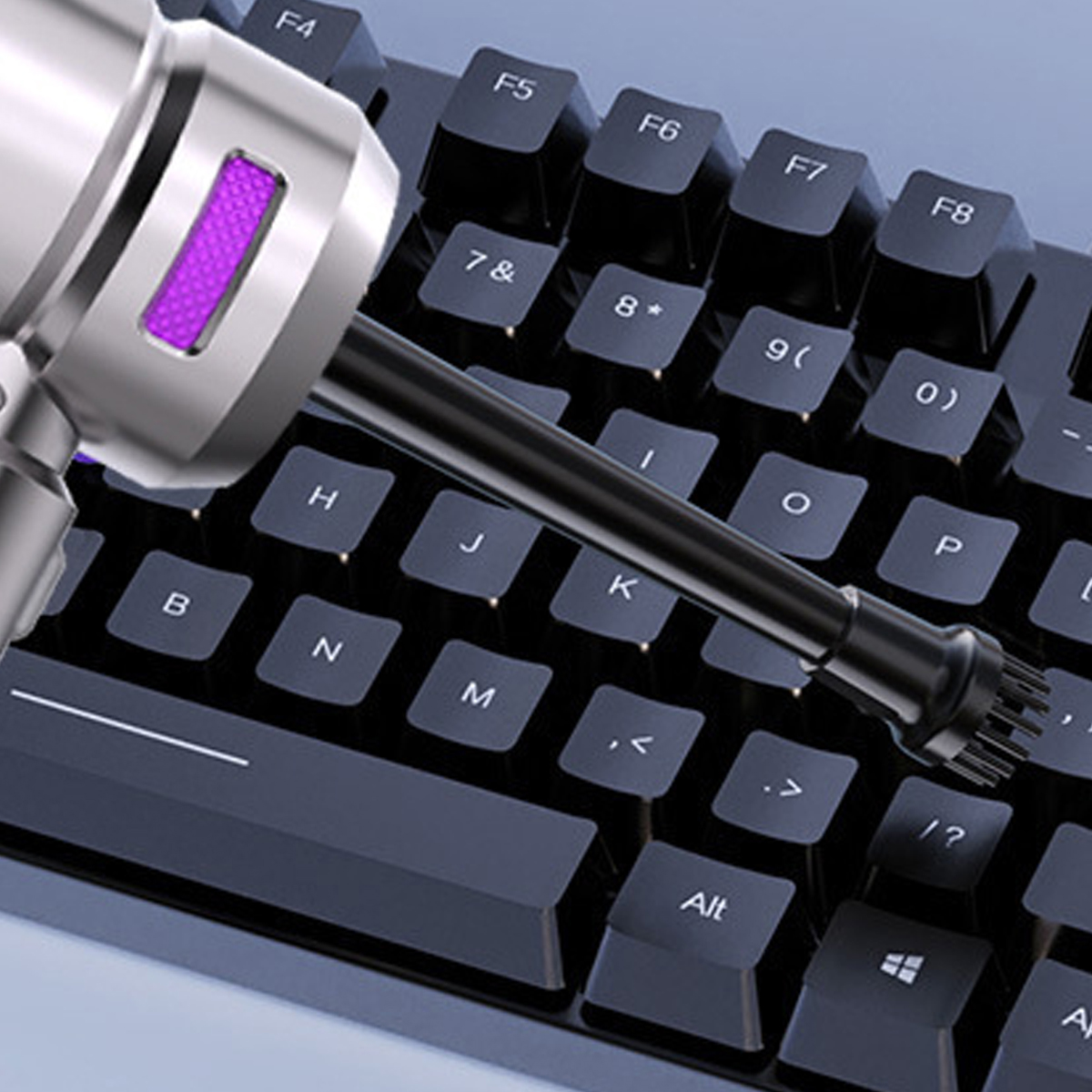 Nahaufnahme einer Tastatur, die mit einem kleinen Luftstaubsauger gereinigt wird. Staubpartikel sind sichtbar.