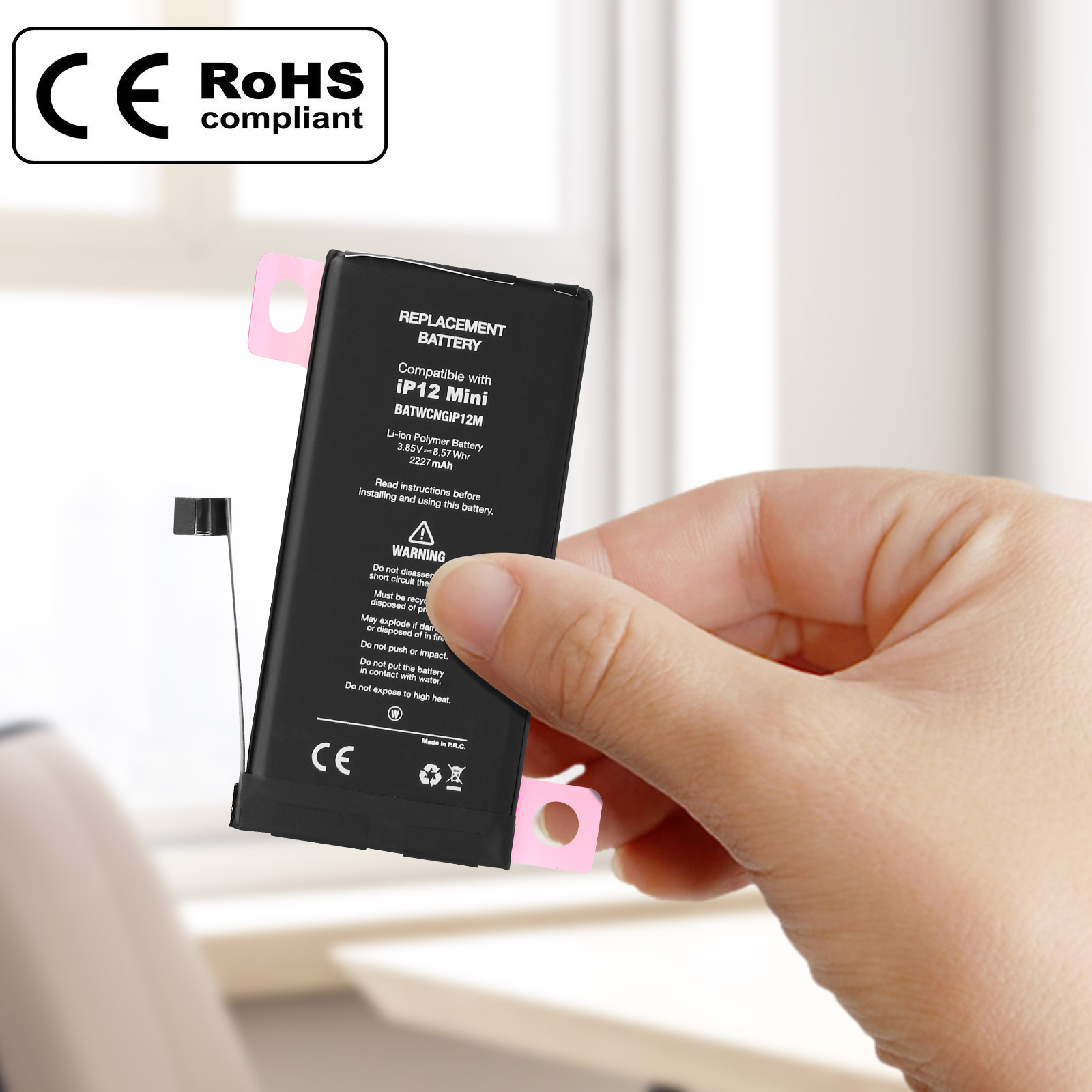 Mano che tiene una batteria per iPhone con adesivi rosa. Ha un'etichetta nera con testo.