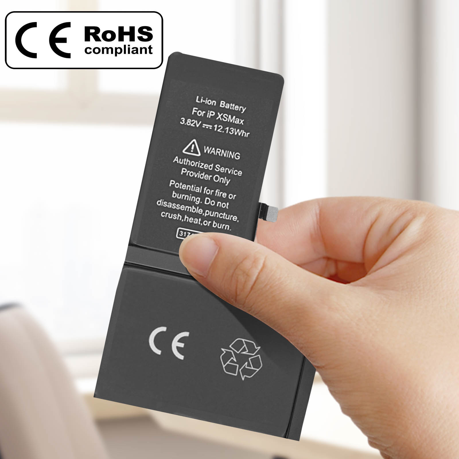 Una mano che tiene una batteria del telefono nera con testo: Attenzione, batteria Li-ion per ip XSMax, e marchi CE, RoHS.