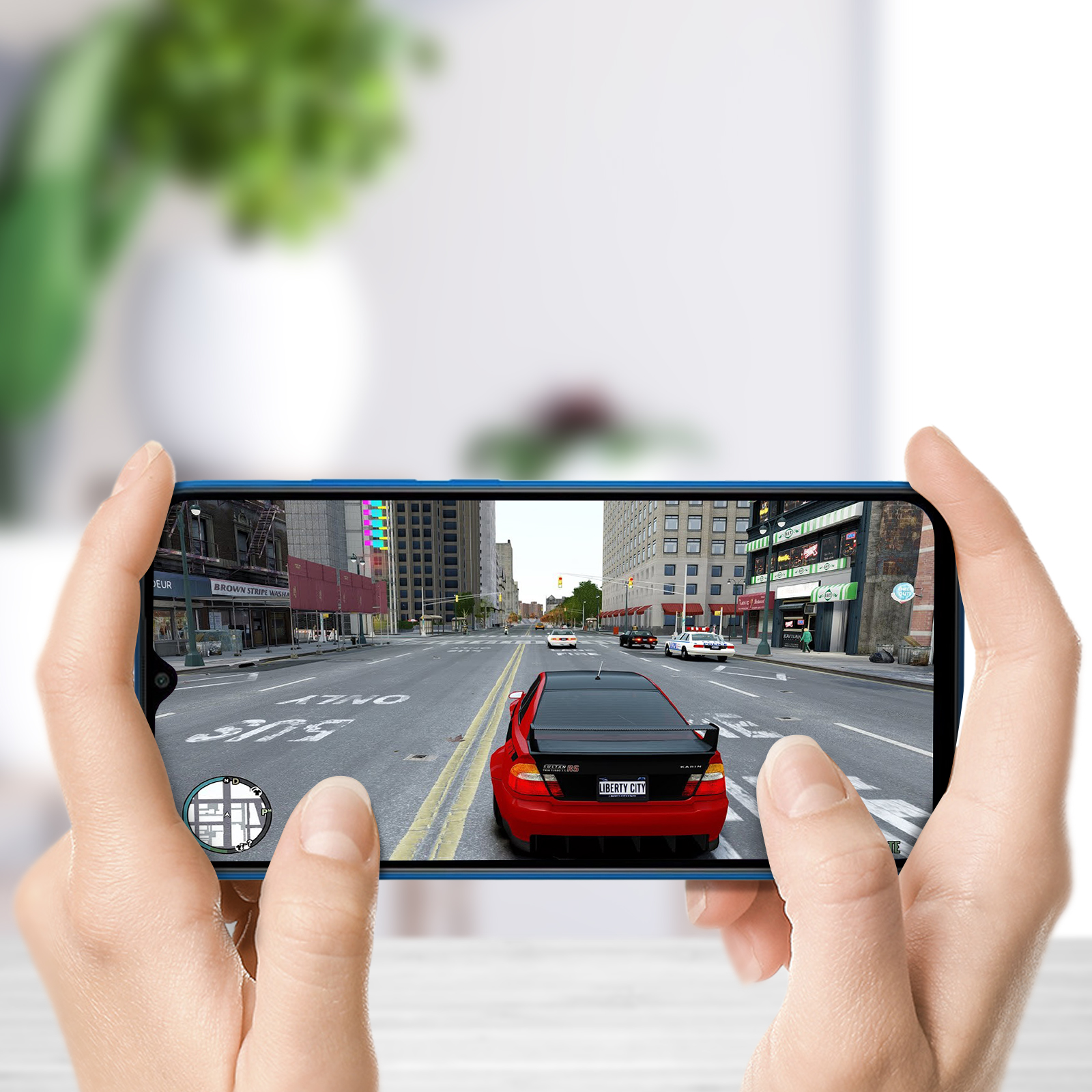 Eine Person hält ein Smartphone, auf dem ein Autorennen-Spiel angezeigt wird. Das Spiel zeigt ein rotes Auto in einer Stadtumgebung.