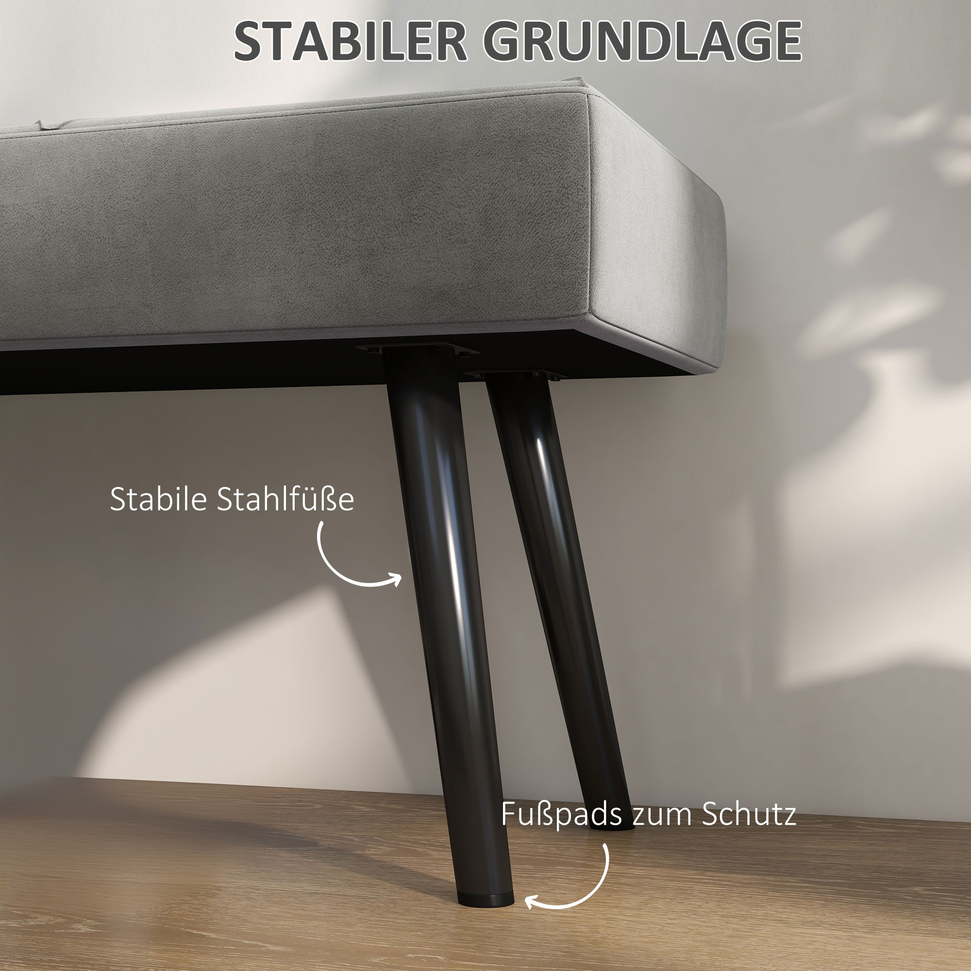 Graue Bank mit schwarzen Beinen. Das Bild betont die stabilen Stahlfüße und die Fußpads zum Schutz.