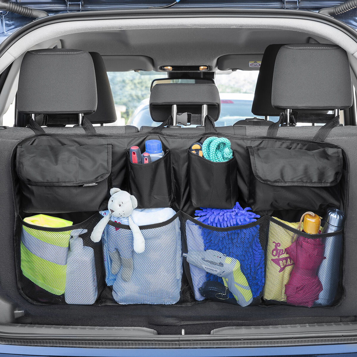 Ein Kofferraum-Organizer mit mehreren Taschen, gefüllt mit Reinigungsmitteln und Spielzeug.