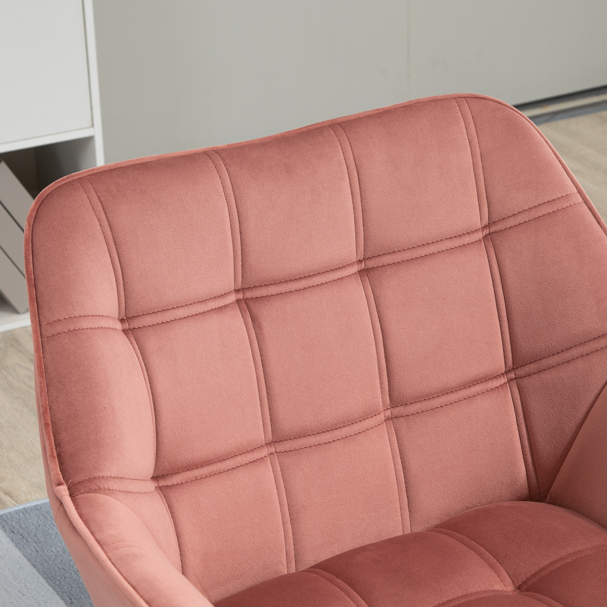 Ein rosa, getufteter Stuhl. Der Stuhl hat ein quadratisches Muster und steht auf hellem Boden.