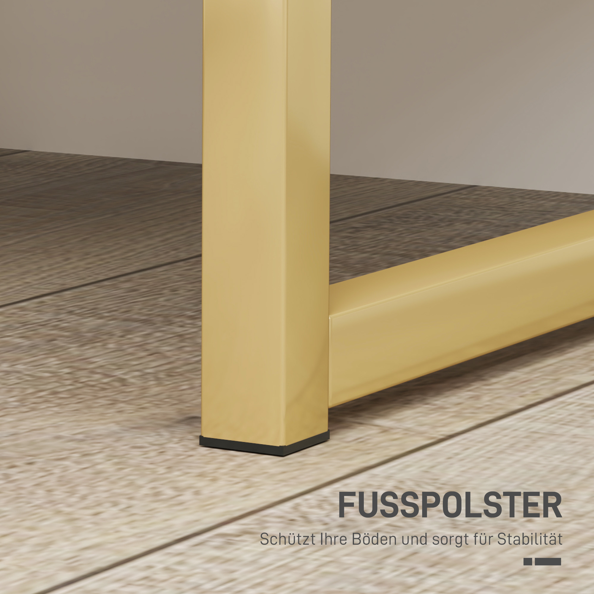 Nahaufnahme eines Tischbeins mit Goldfinish. Auf der Unterseite des Beins befindet sich ein schwarzes Pad. Holzboden.