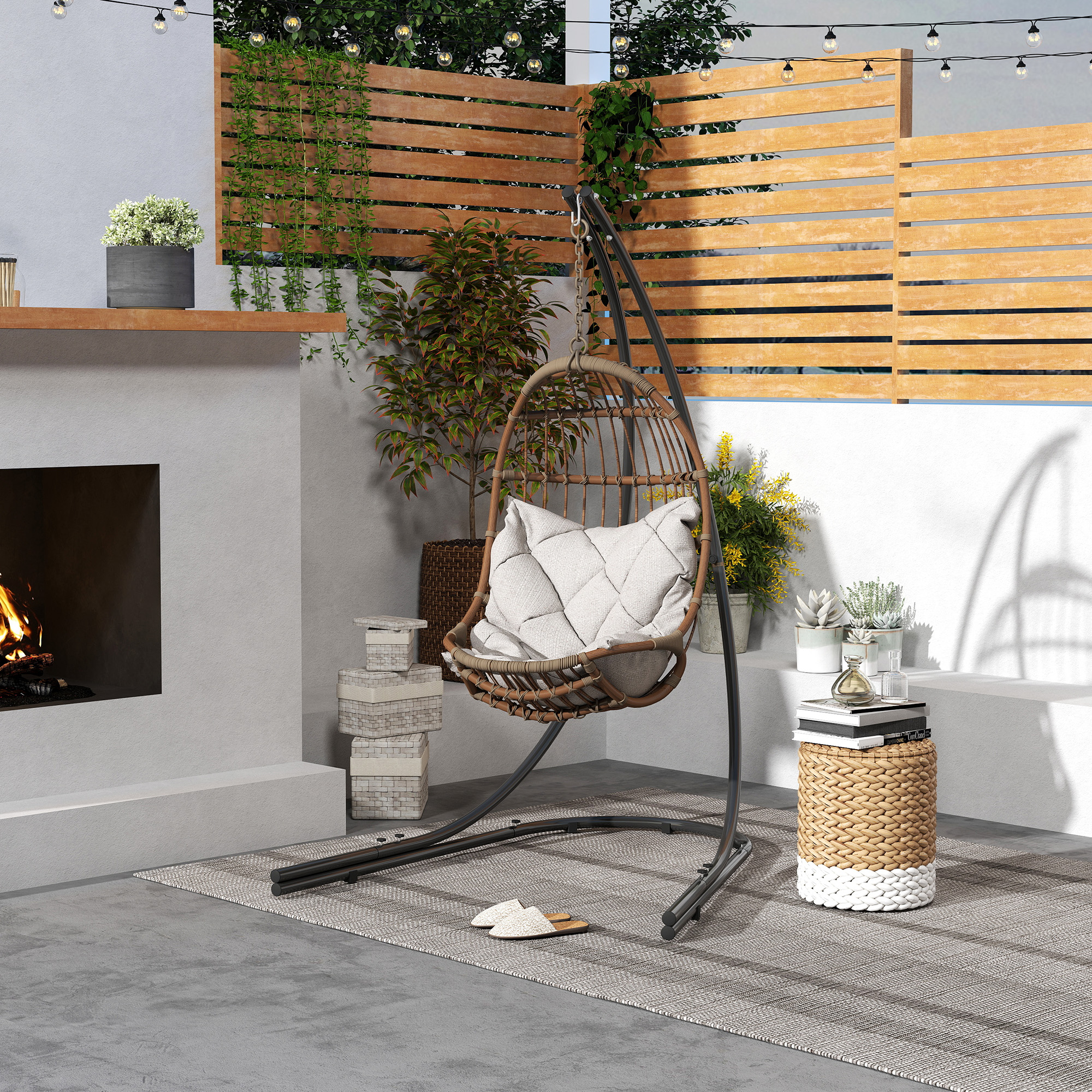 Szene im Freien mit Hängesessel, Kamin und Pflanzen. Eine gemütliche Terrasse mit Holzzaun.