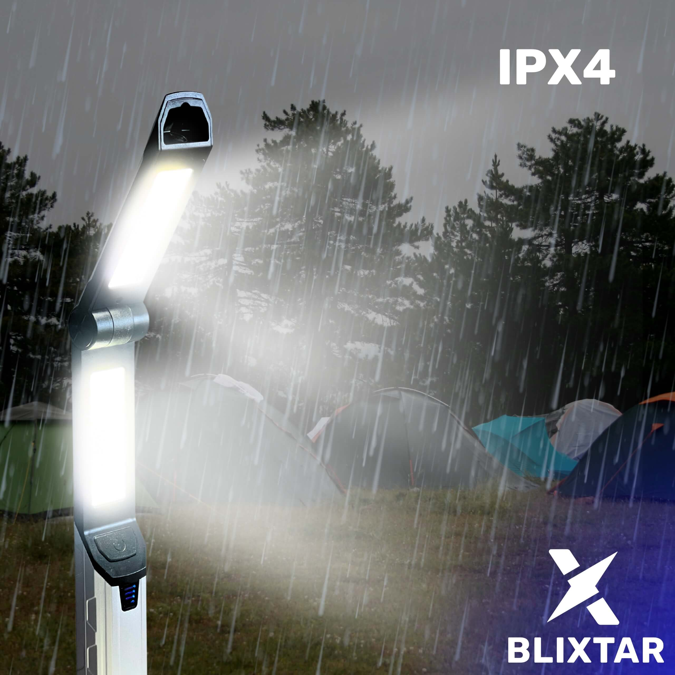 Czarna i srebrna latarka w deszczu. Deszcz pada przed lasem i namiotami.