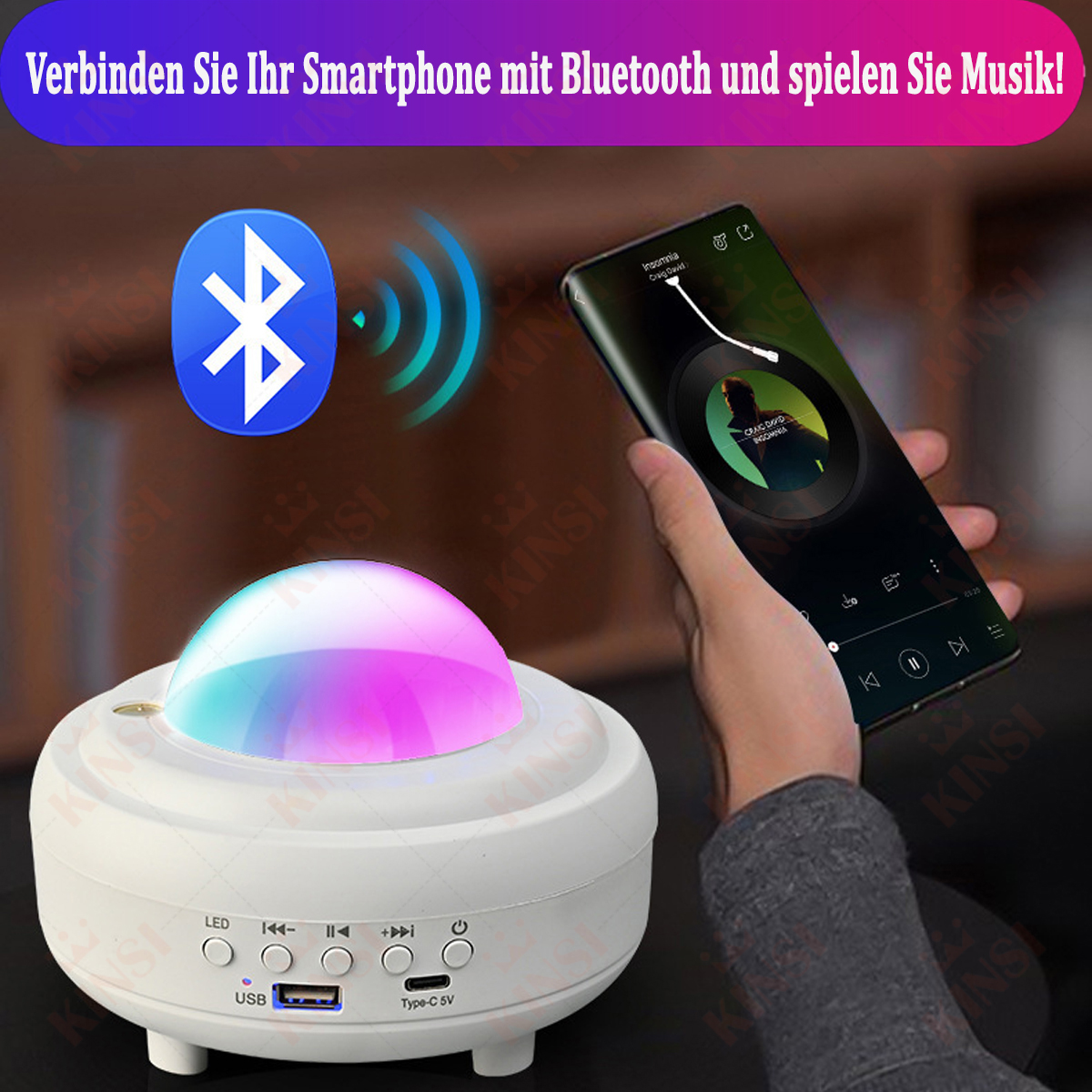 Weißes Gerät mit farbigem Licht, das ein Bluetooth-Symbol projiziert. Eine Hand hält ein Telefon.