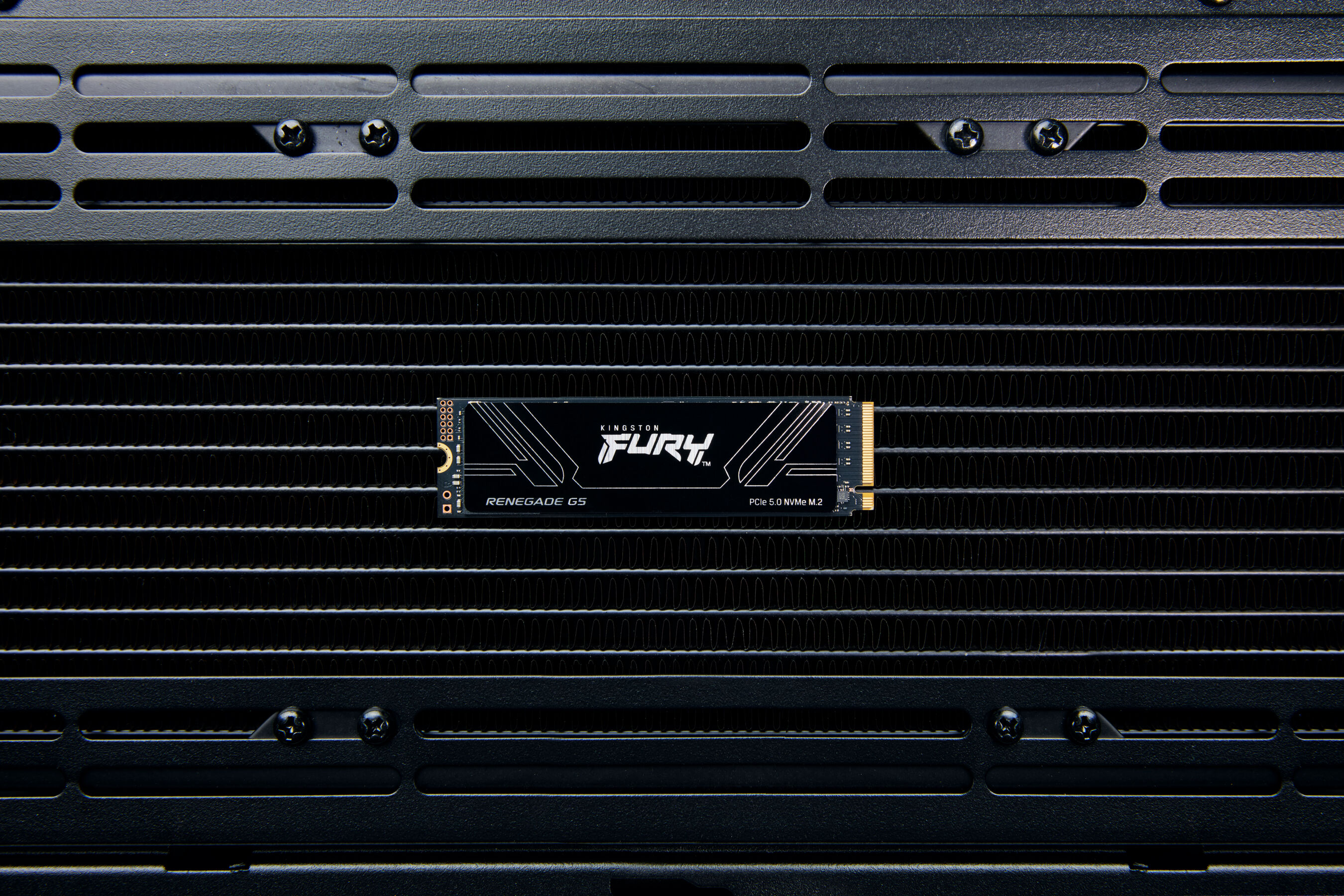 Dysk SSD Kingston FURY Renegade Gen5 zainstalowany na czarnym metalowym radiatorze.