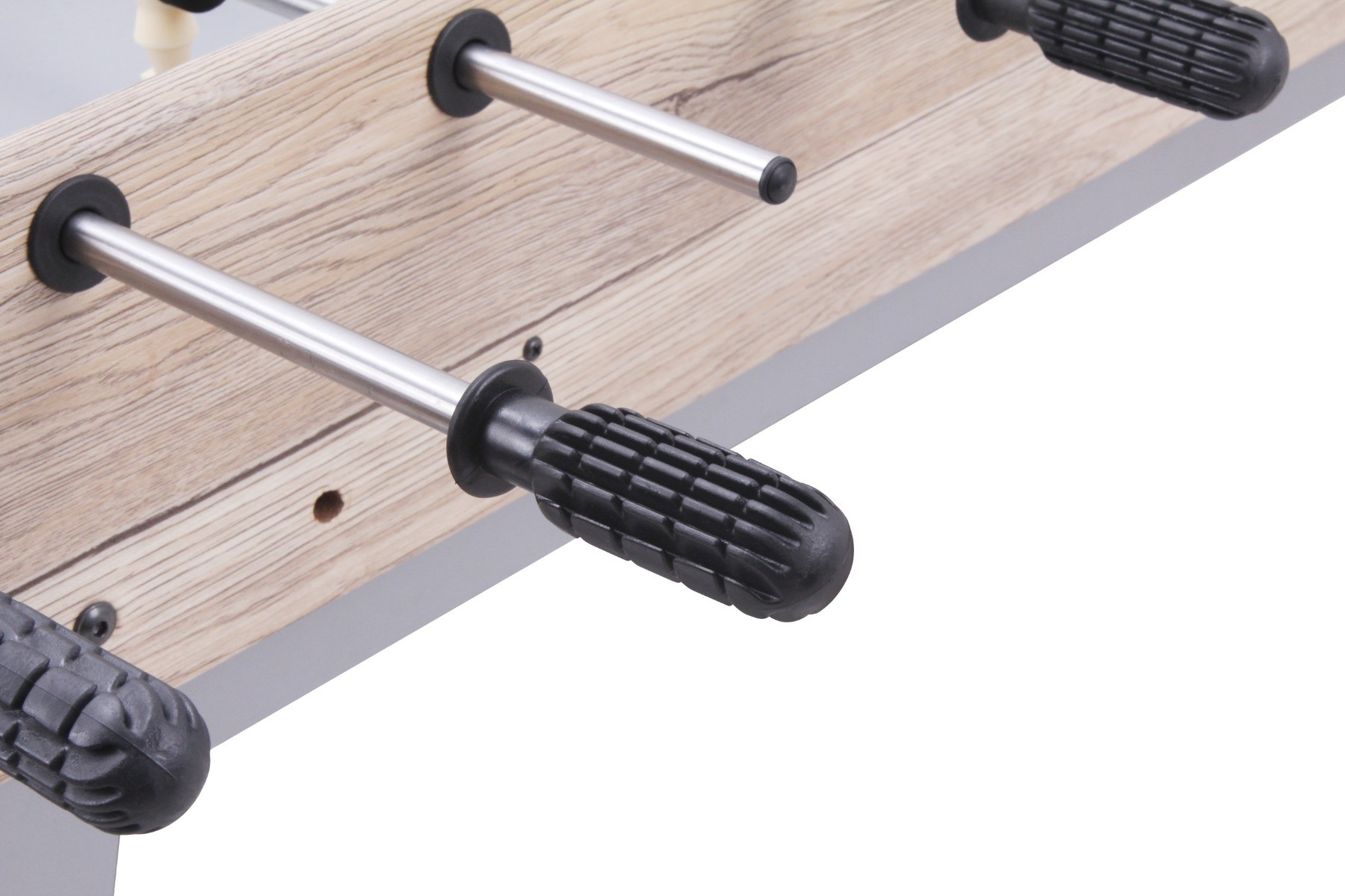 Tafelvoetbaltafel detail: houten oppervlak, metalen staven met zwarte handvatten en een witte achtergrond.