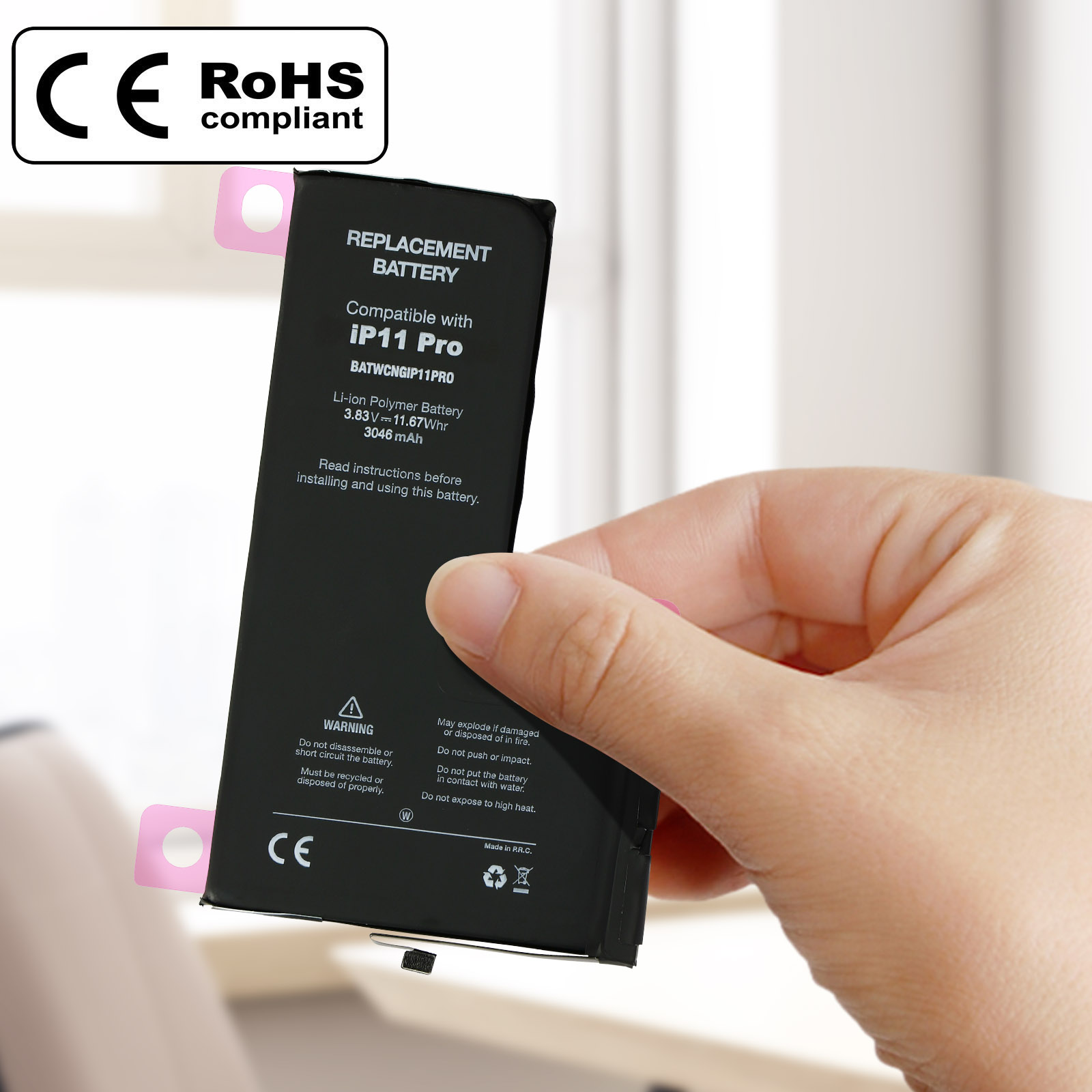 Mano che tiene una batteria di ricambio per iPhone, con avvertenze ed etichette CE/RoHS.