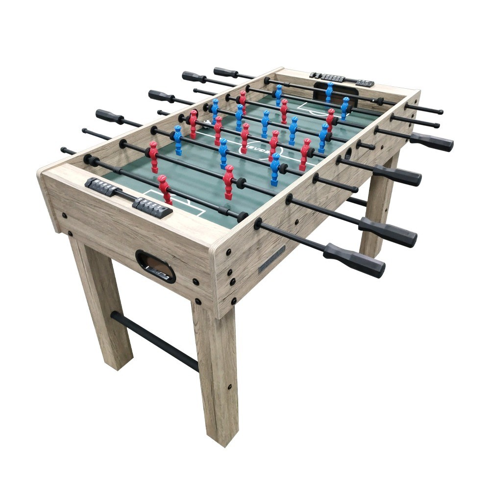Tafelvoetbaltafel met rode en blauwe spelers op een groen veld, houten frame, zwarte handvatten, witte achtergrond.