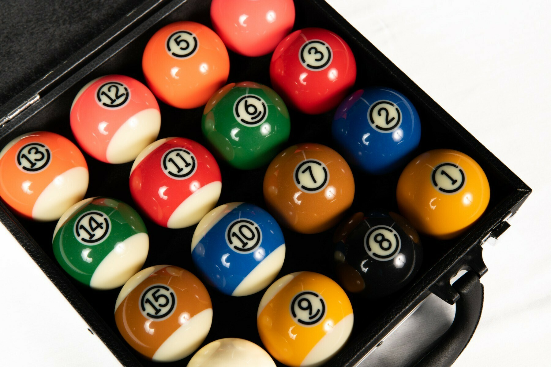 Een zwarte koffer met 15 genummerde biljartballen.