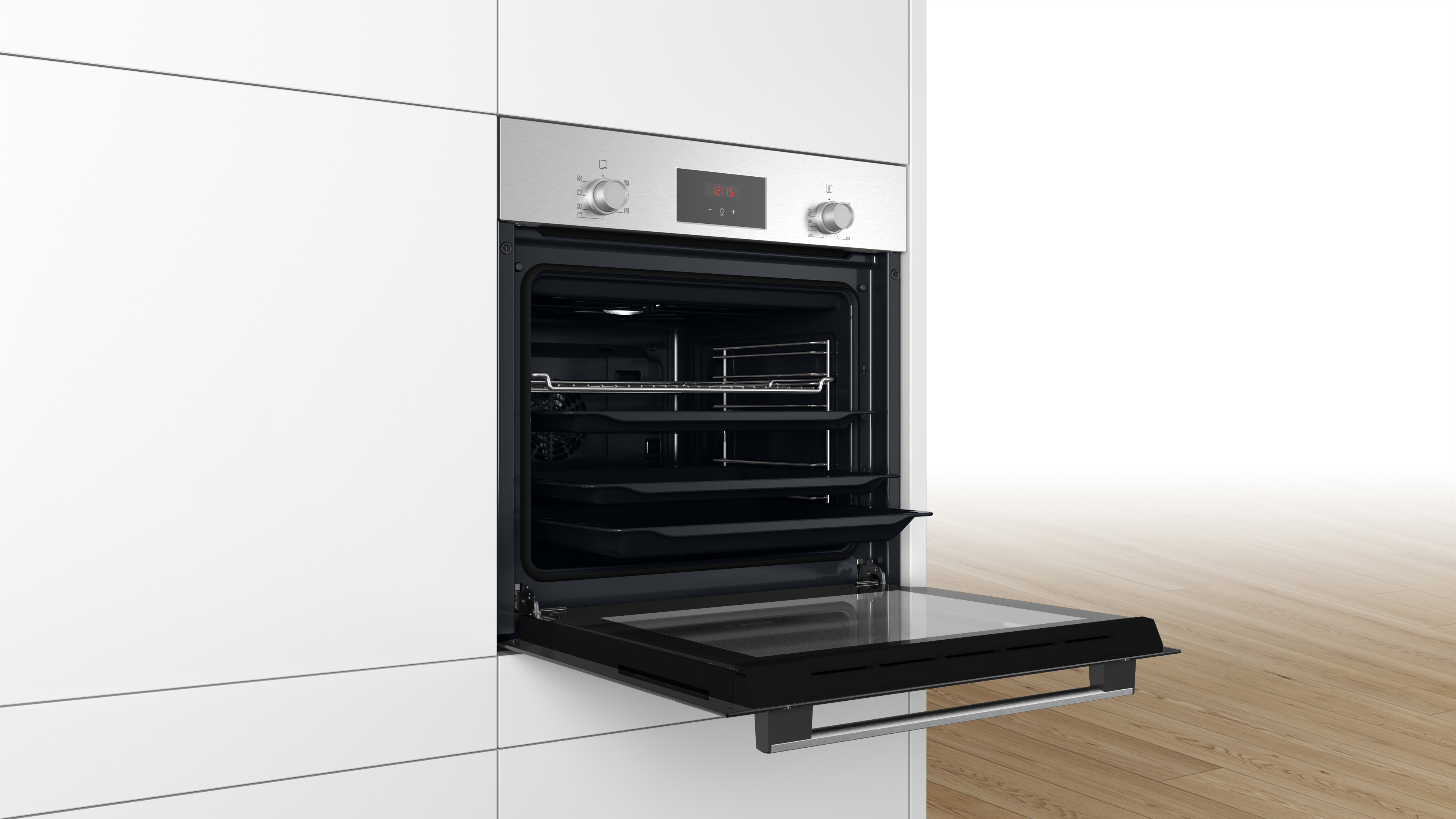 Forno argentato aperto. All'interno un vassoio e una griglia. È integrato in mobili bianchi.