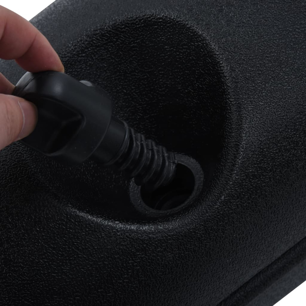 Mano che inserisce un ugello nero per pompa in una base nera.
