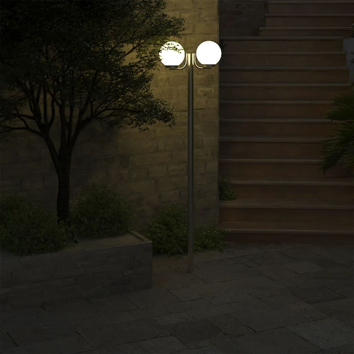 Lampione da giardino a due luci con globi bianchi, muro in mattoni.