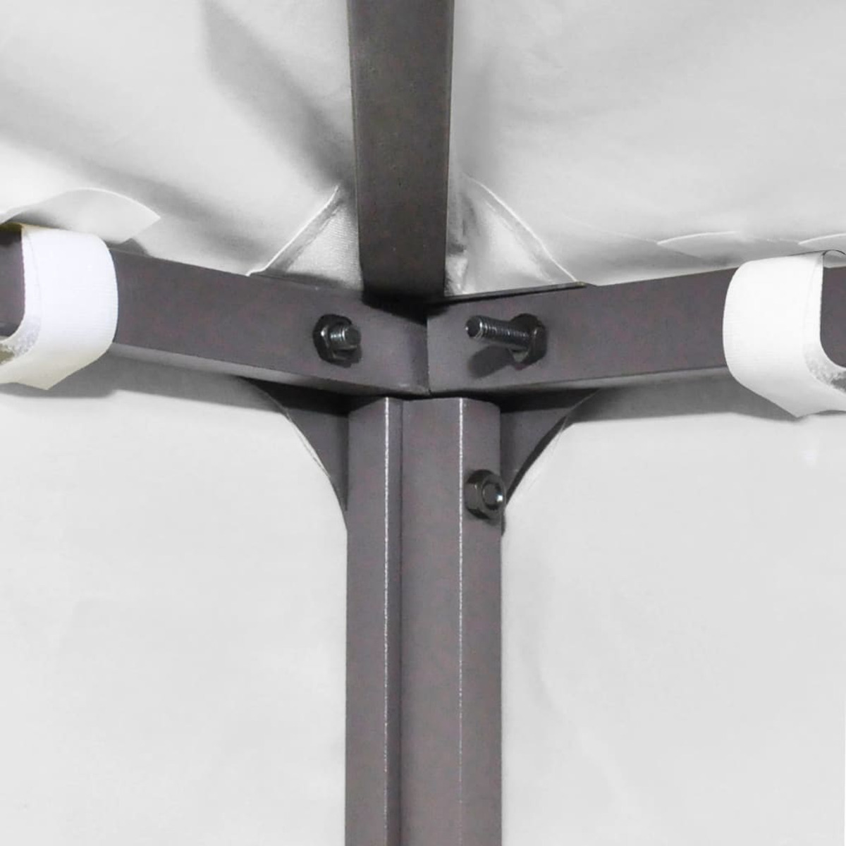 Un primo piano di un angolo del telaio di una tenda. Il tessuto è bianco e il telaio è in metallo.