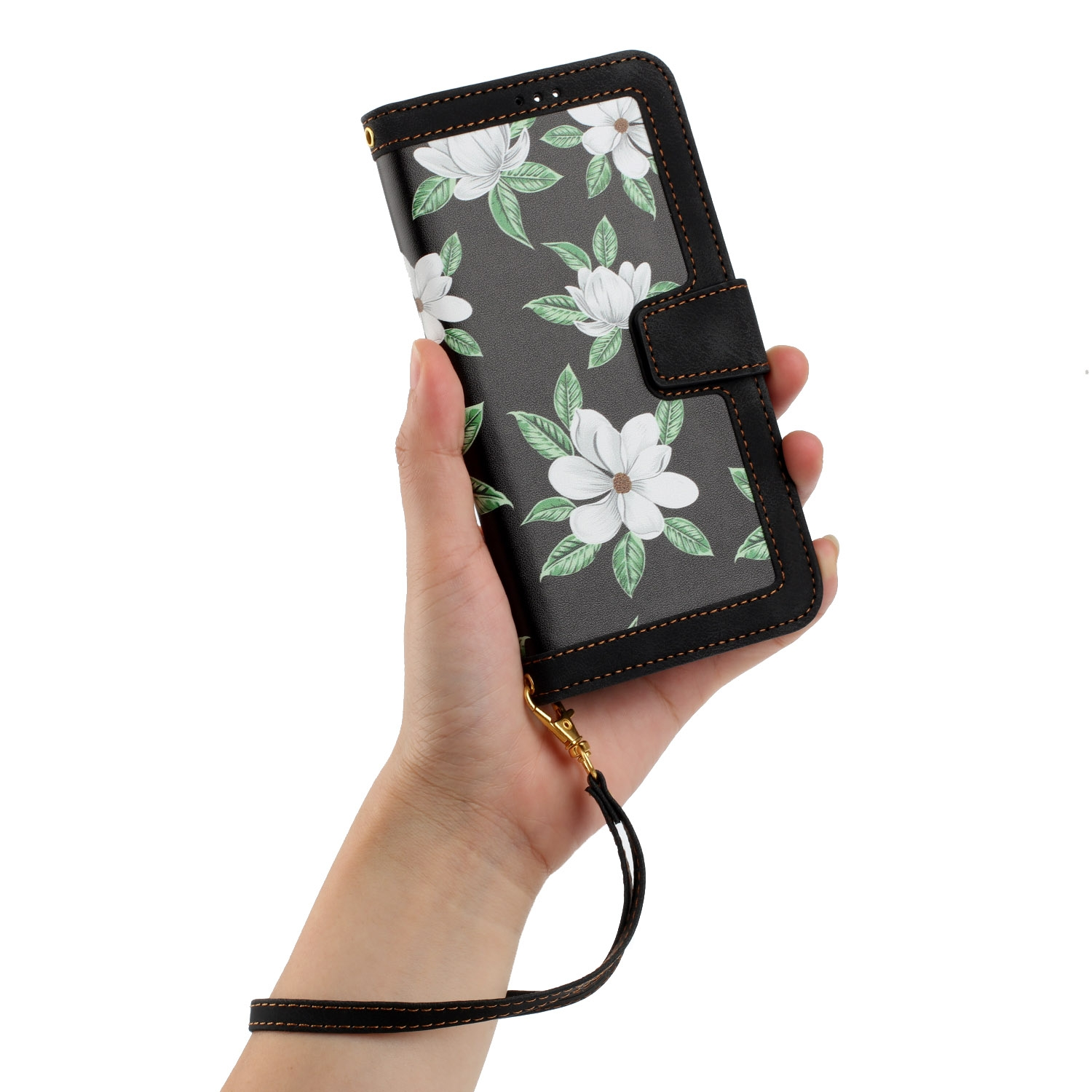 Mano sosteniendo una funda de teléfono con un diseño floral. La funda es negra, con flores blancas.