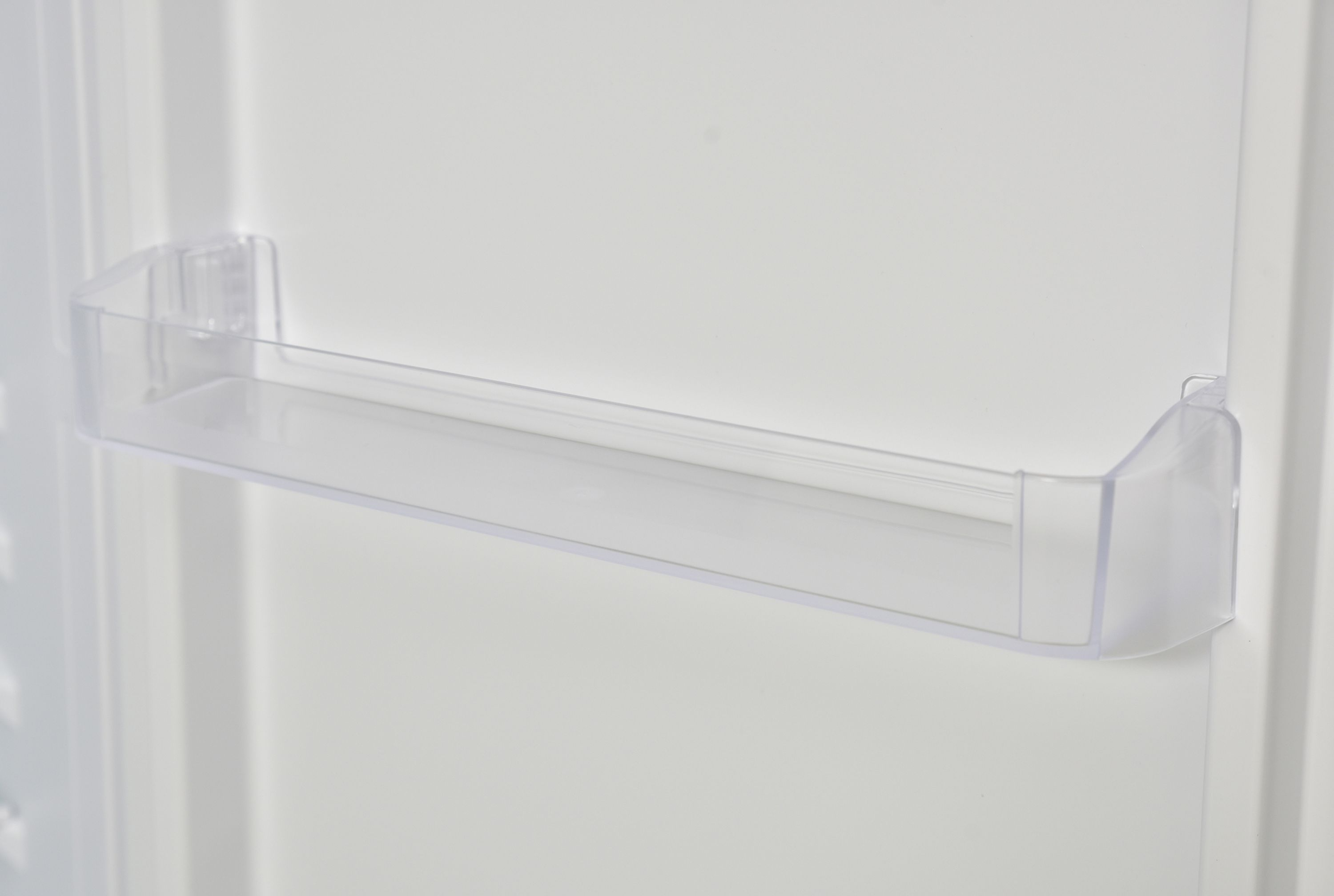 Transparente Kunststoff-Kühlschranktürablage. Weißer Hintergrund.