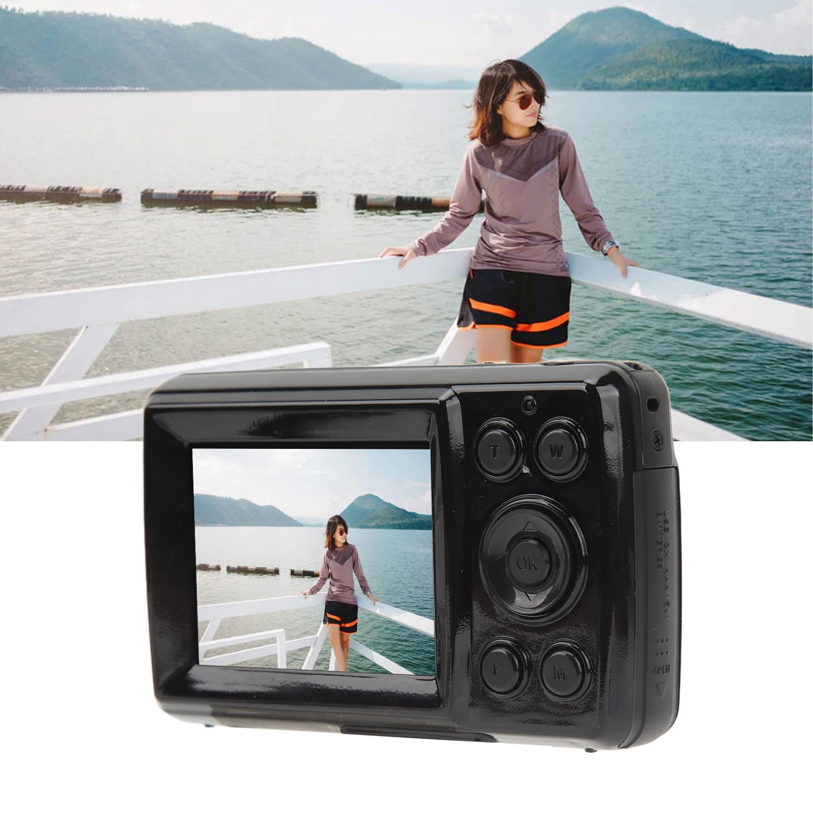 Osoba robi zdjęcie aparatem, w tle jezioro i góry.