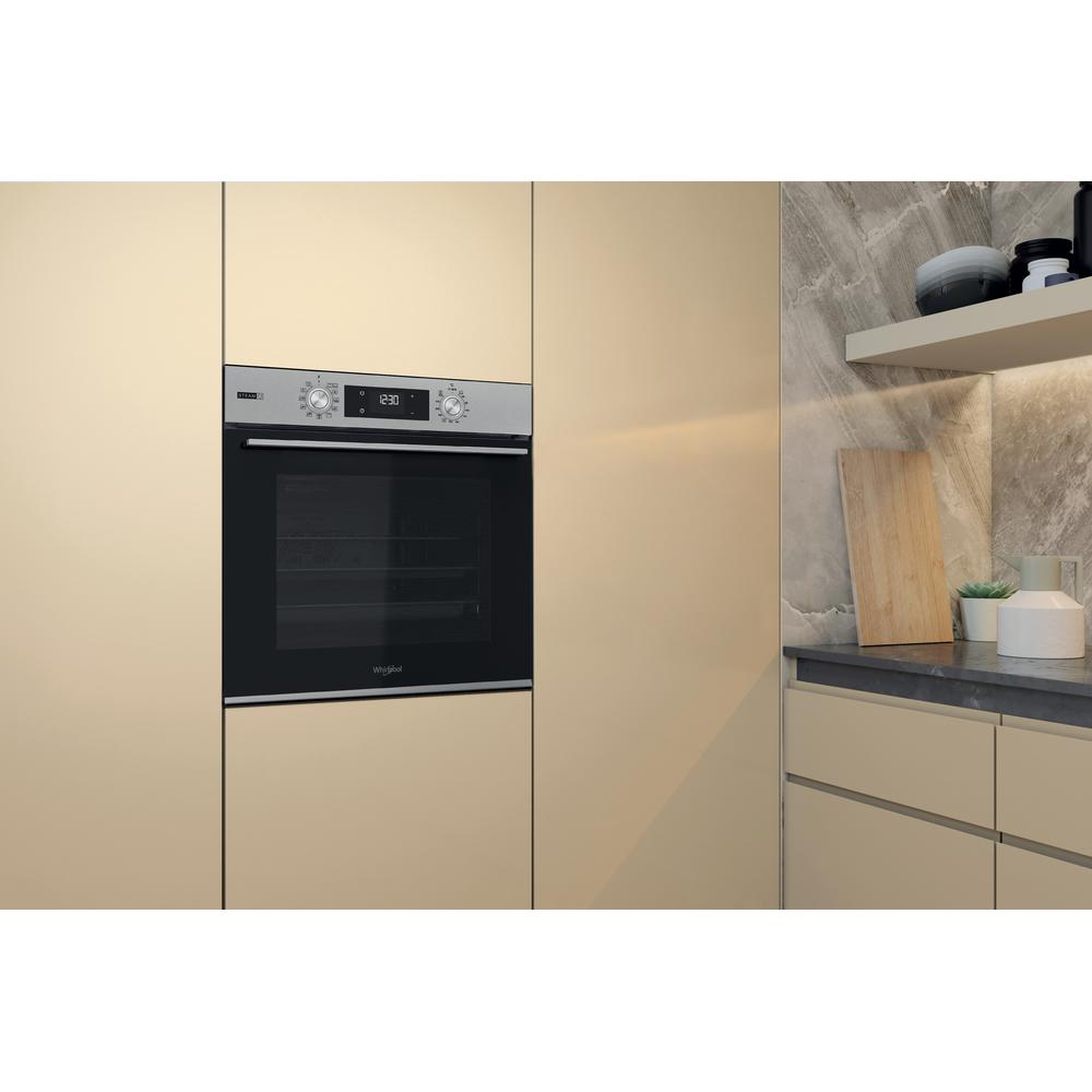 Forno a incasso in armadio beige, con porta nera e display digitale.