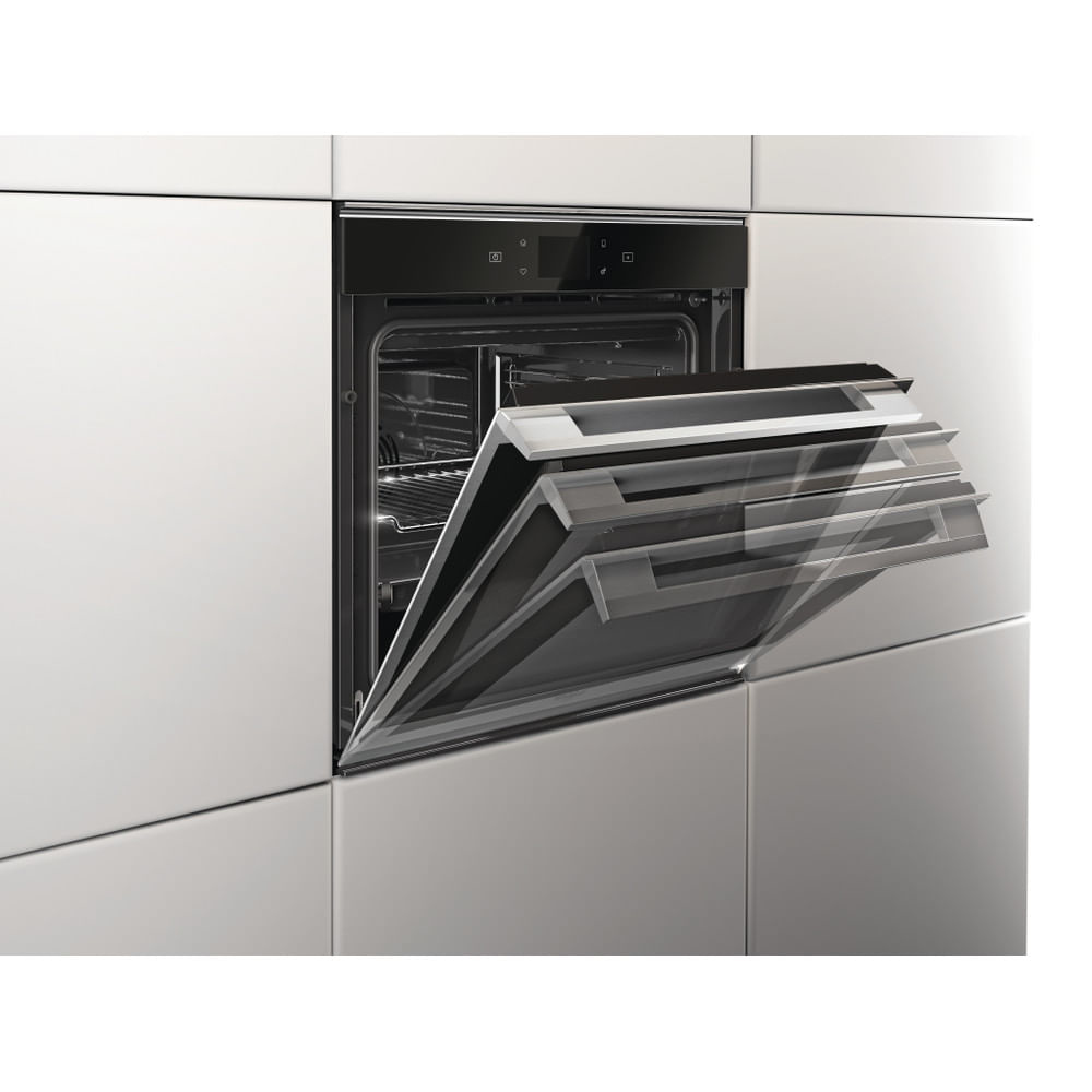 Un forno incassato in una parete, con la porta parzialmente aperta, che rivela l'interno.