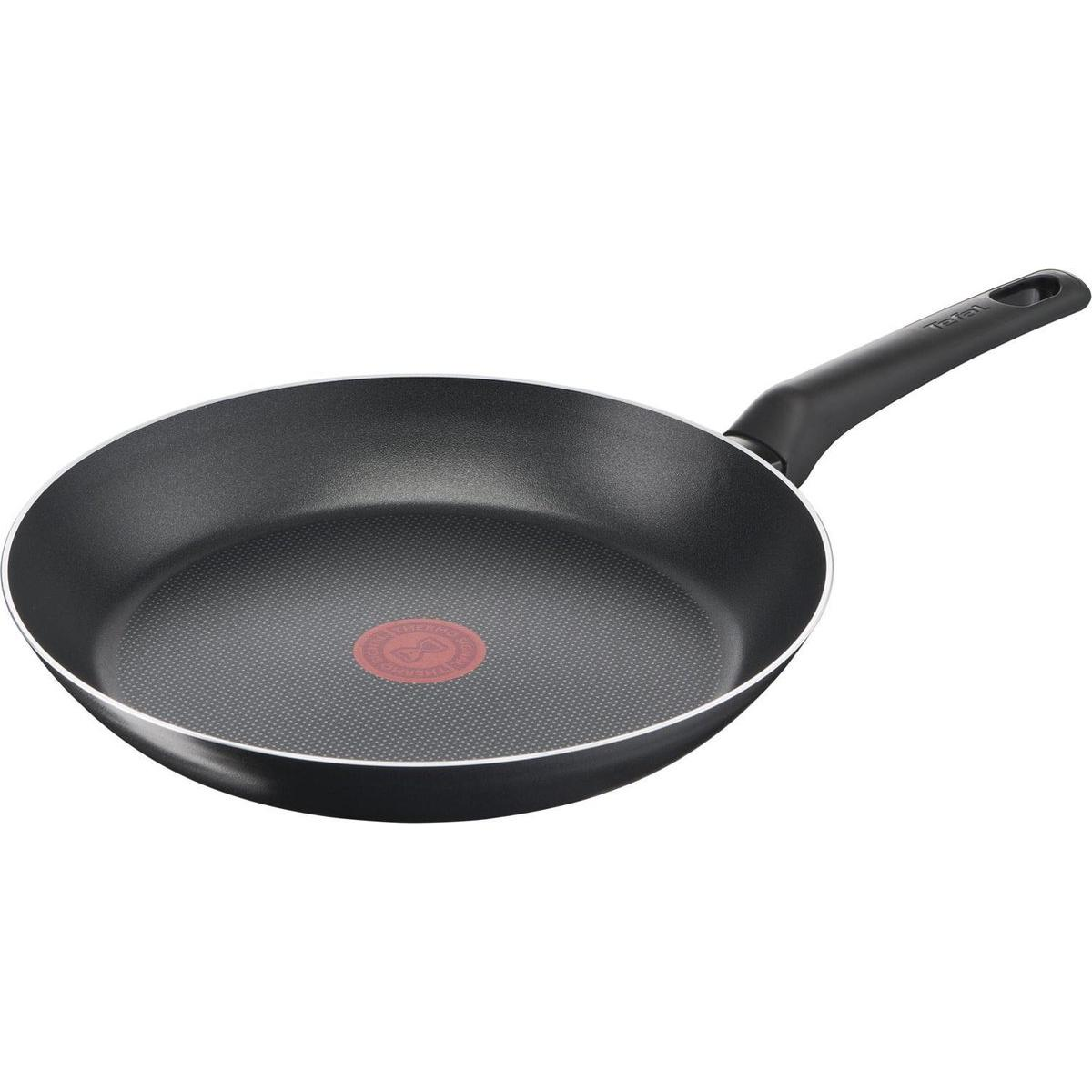 Black frying pan with a red dot in the center. The pan has a black handle.