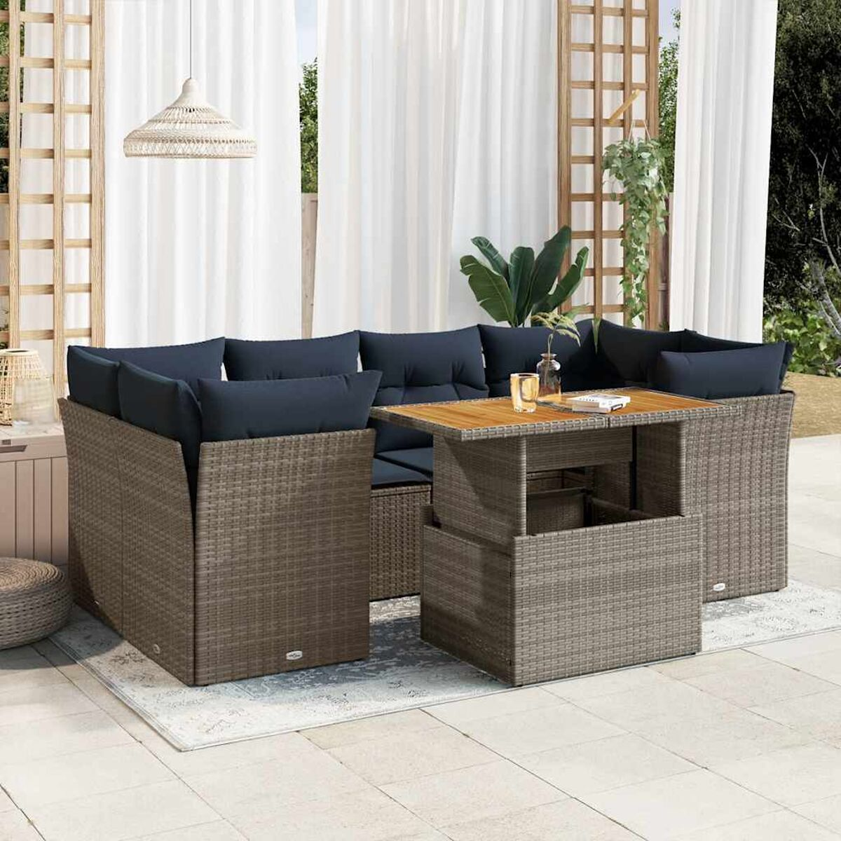 Set di mobili da patio con tavolo e sedie, su un tappeto, in un ambiente esterno soleggiato.