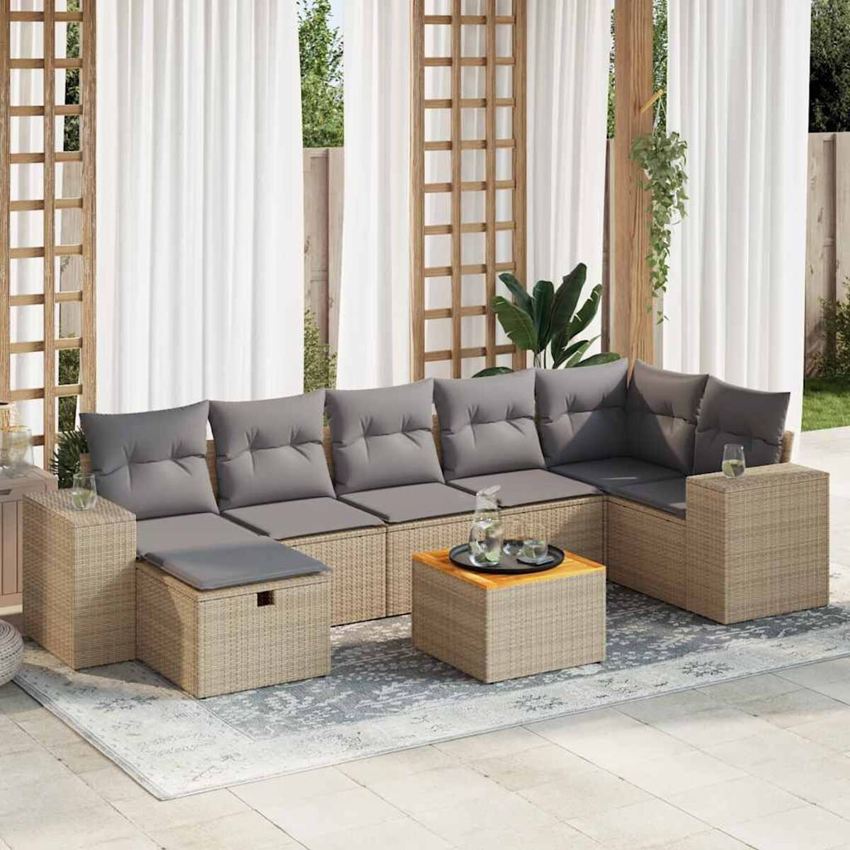 Set di sedute per esterni con divani in vimini beige, cuscini grigi e un tavolino in legno, su un tappeto grigio chiaro.