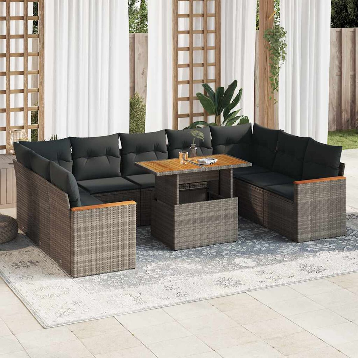 Set divano in rattan per esterni con cuscini grigio scuro. Il set include un tavolo e cuscini.