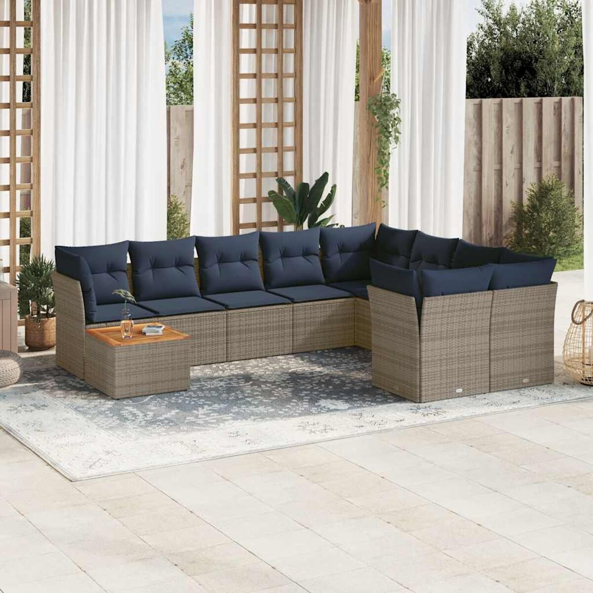 Set di sedute per esterni con cuscini blu e un tavolo in legno con un bicchiere.