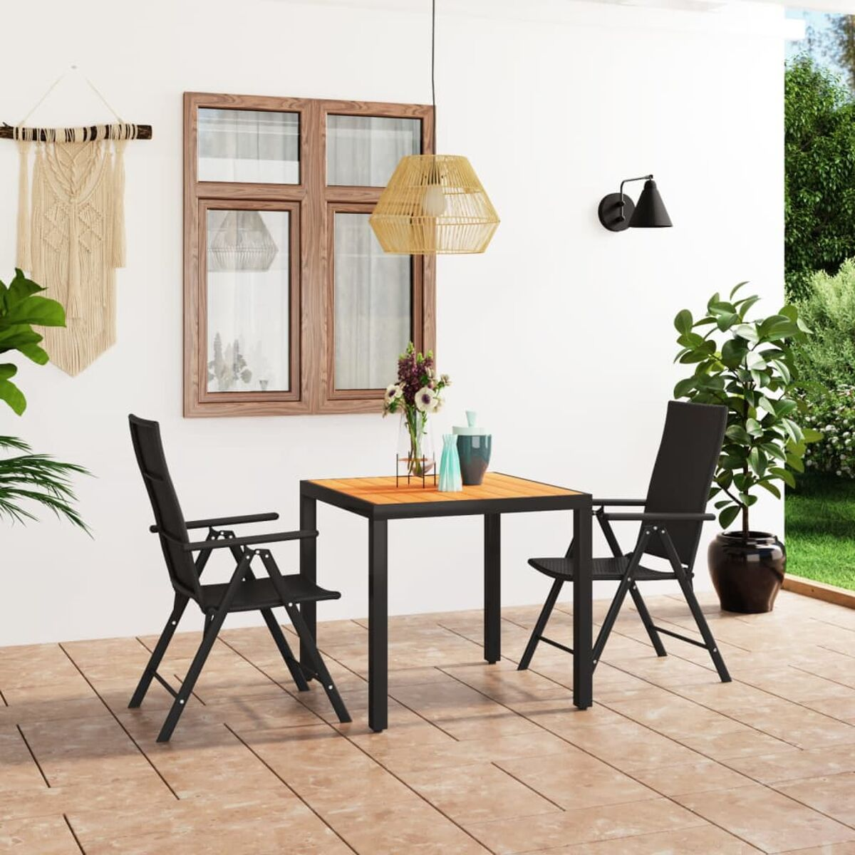 Essbereich im Freien mit Tisch und zwei Stühlen. Blumen und eine Leuchte sind sichtbar.